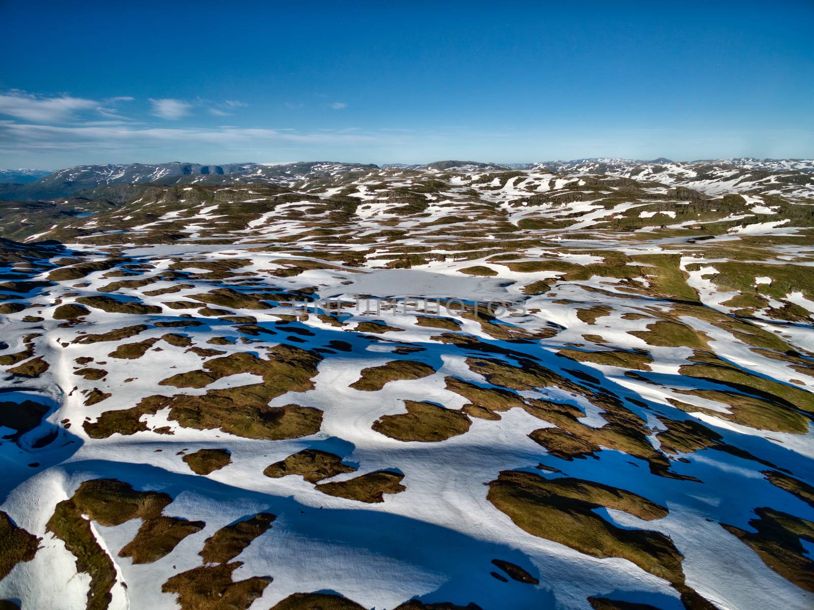 Aerial view of snow covered norwegian landscape on sunny summer day