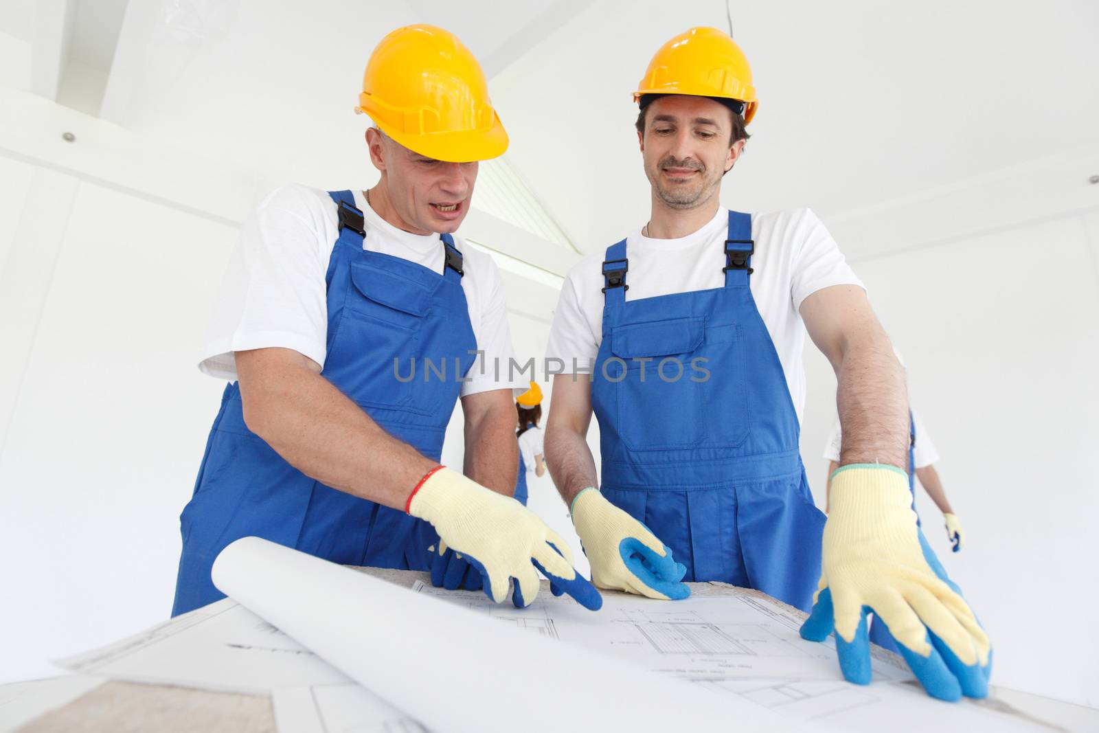 Workers in workwear looking at construction plan