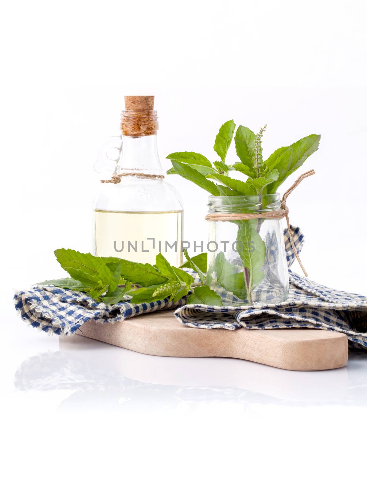 Branch of fresh holy basil in bowl on cutting board isolate on white background.