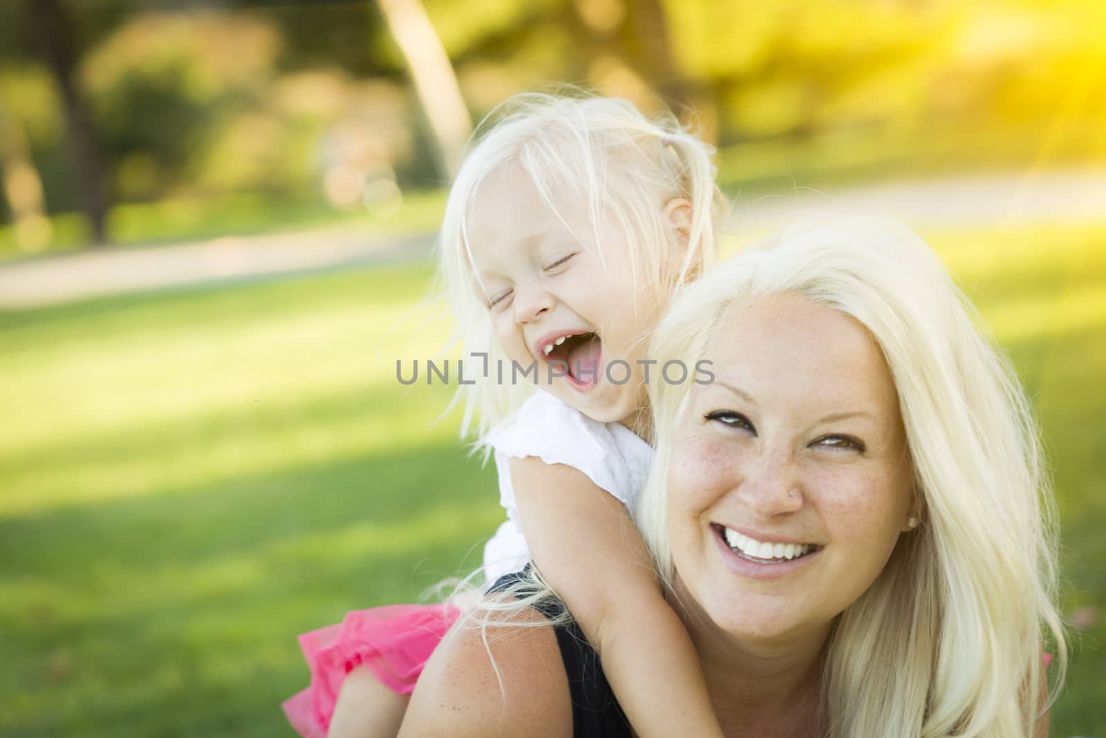 Pretty Mother and Little Girl Having Fun Together in the Grass.