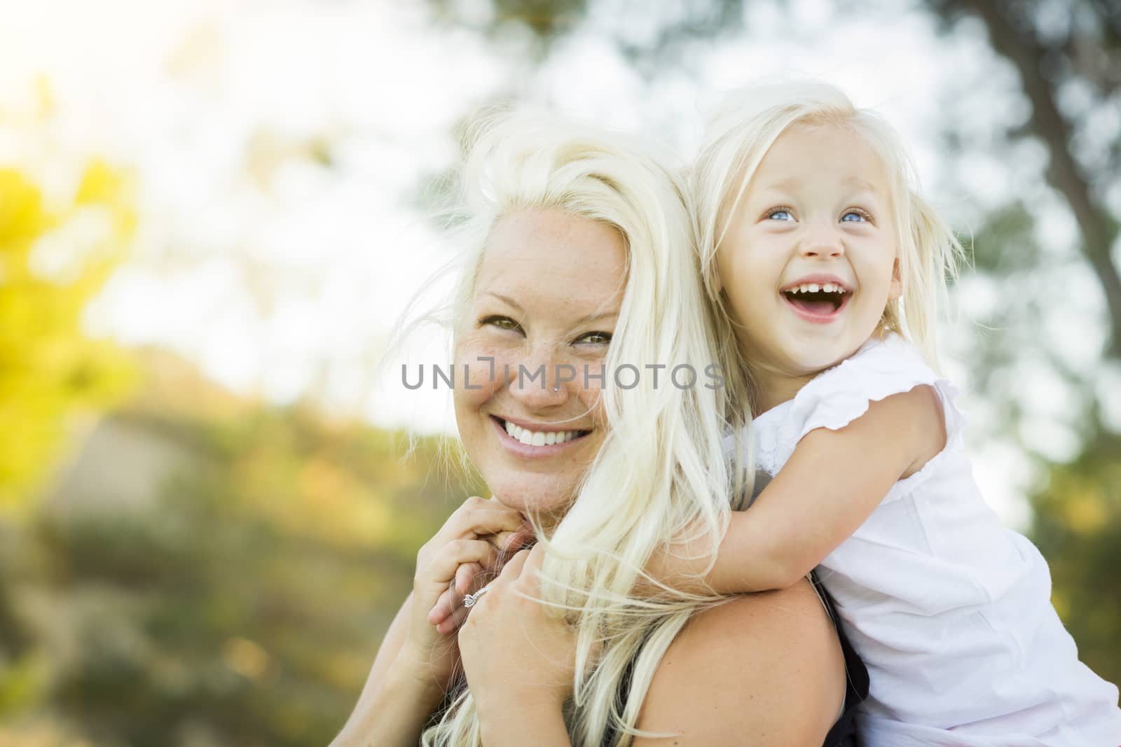 Pretty Mother and Little Girl Having Fun Together in the Grass.