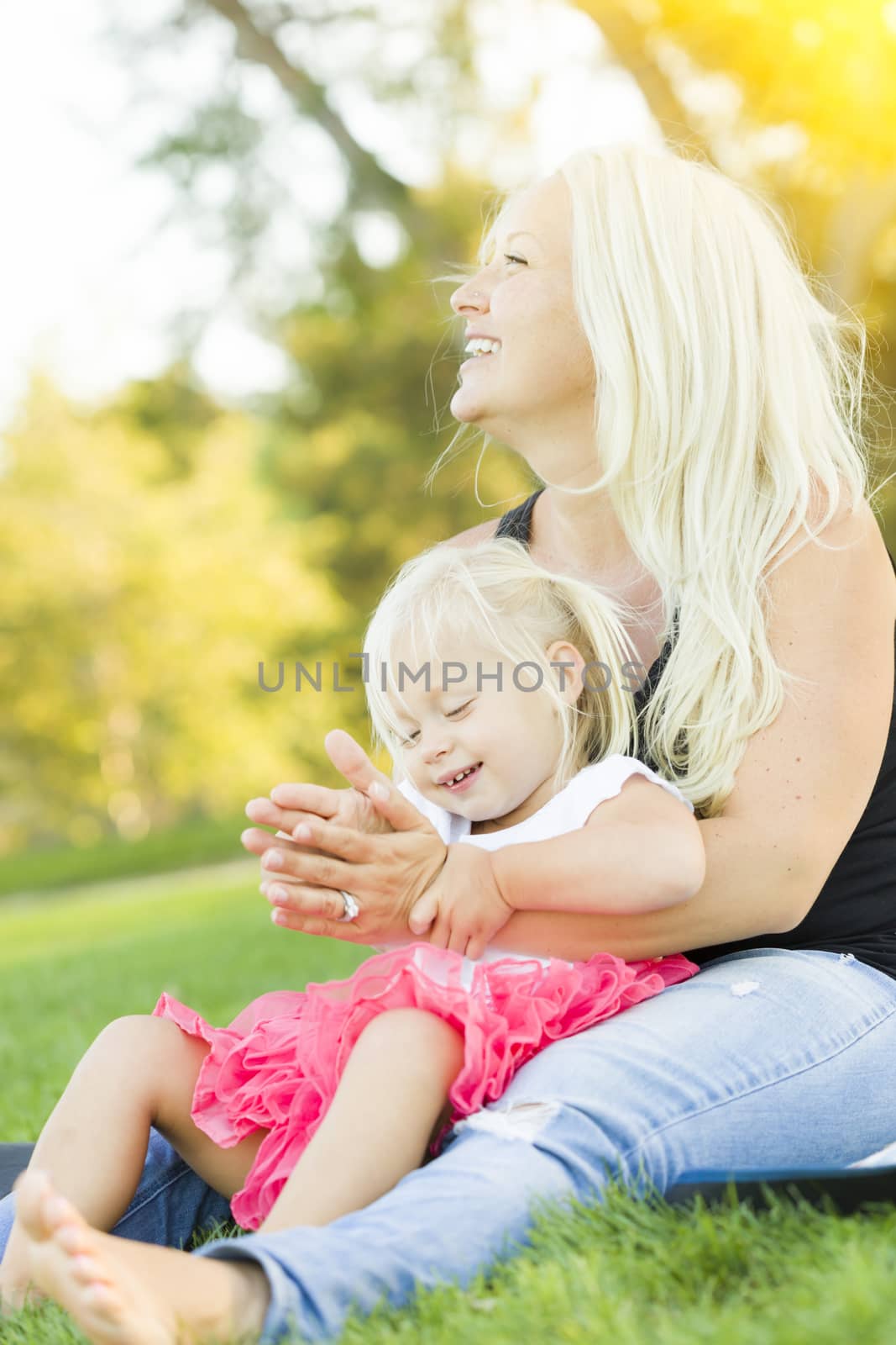 Pretty Mother and Little Girl Having Fun Together in the Grass.