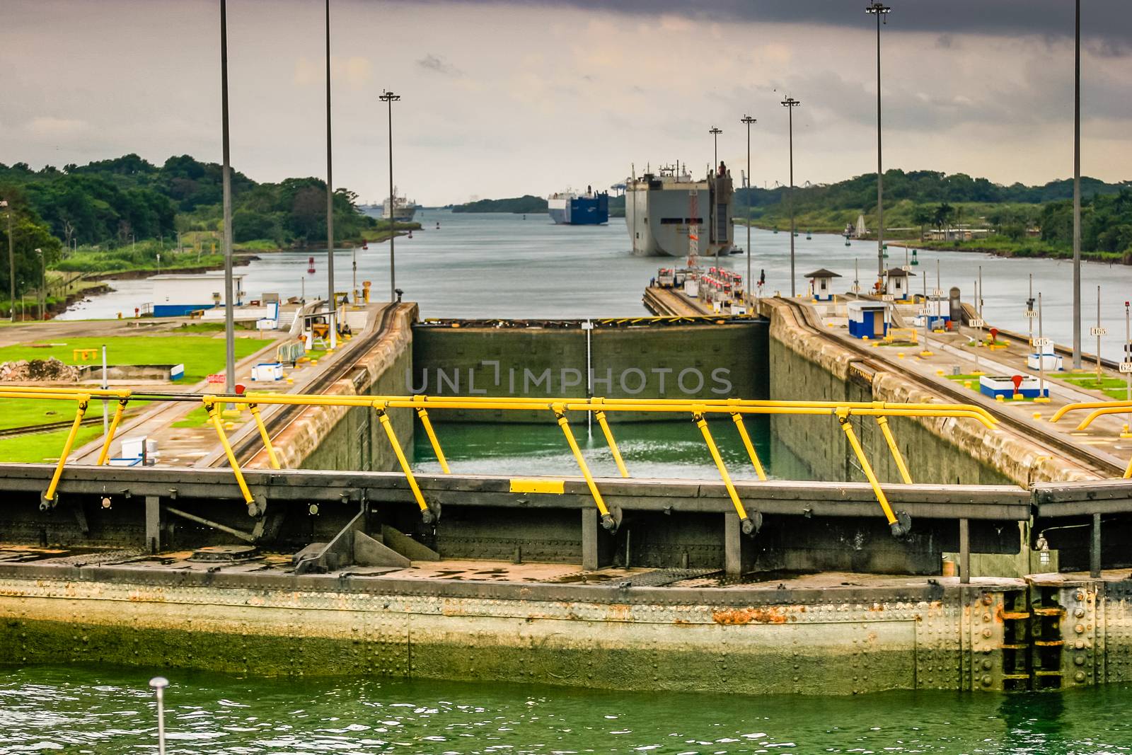 The view from the bridge of a ship transiting the Panama Canal. Stormy skys, in the lock.