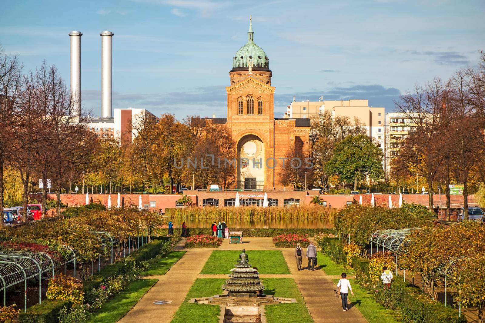 Berlin, Germany - October 26, 2013: Square Michaelkirchplatz with Saint-Michael-Church - park with indian fountain in the foreground in Berlin-Mitte/Luisenstadt.