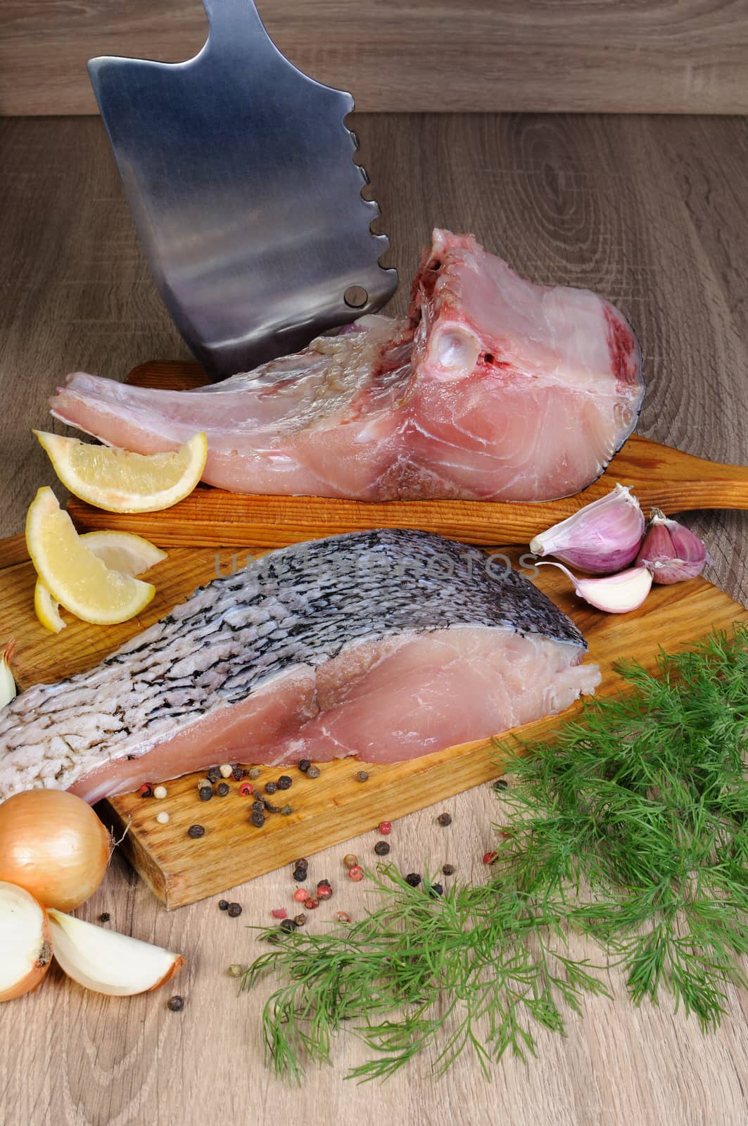 Raw piece  carp on wooden board with fresh herbs and spices