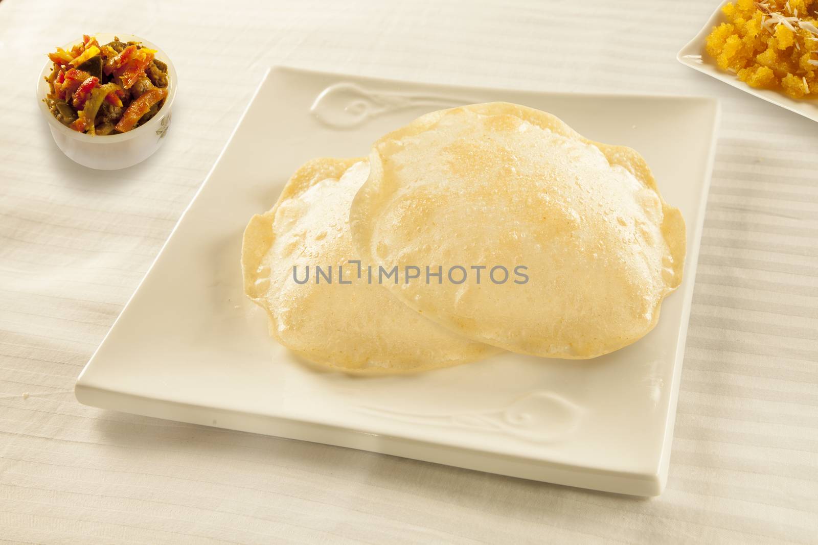 Fried flat bread puri with halwa sweet and achaar pickles  by haiderazim