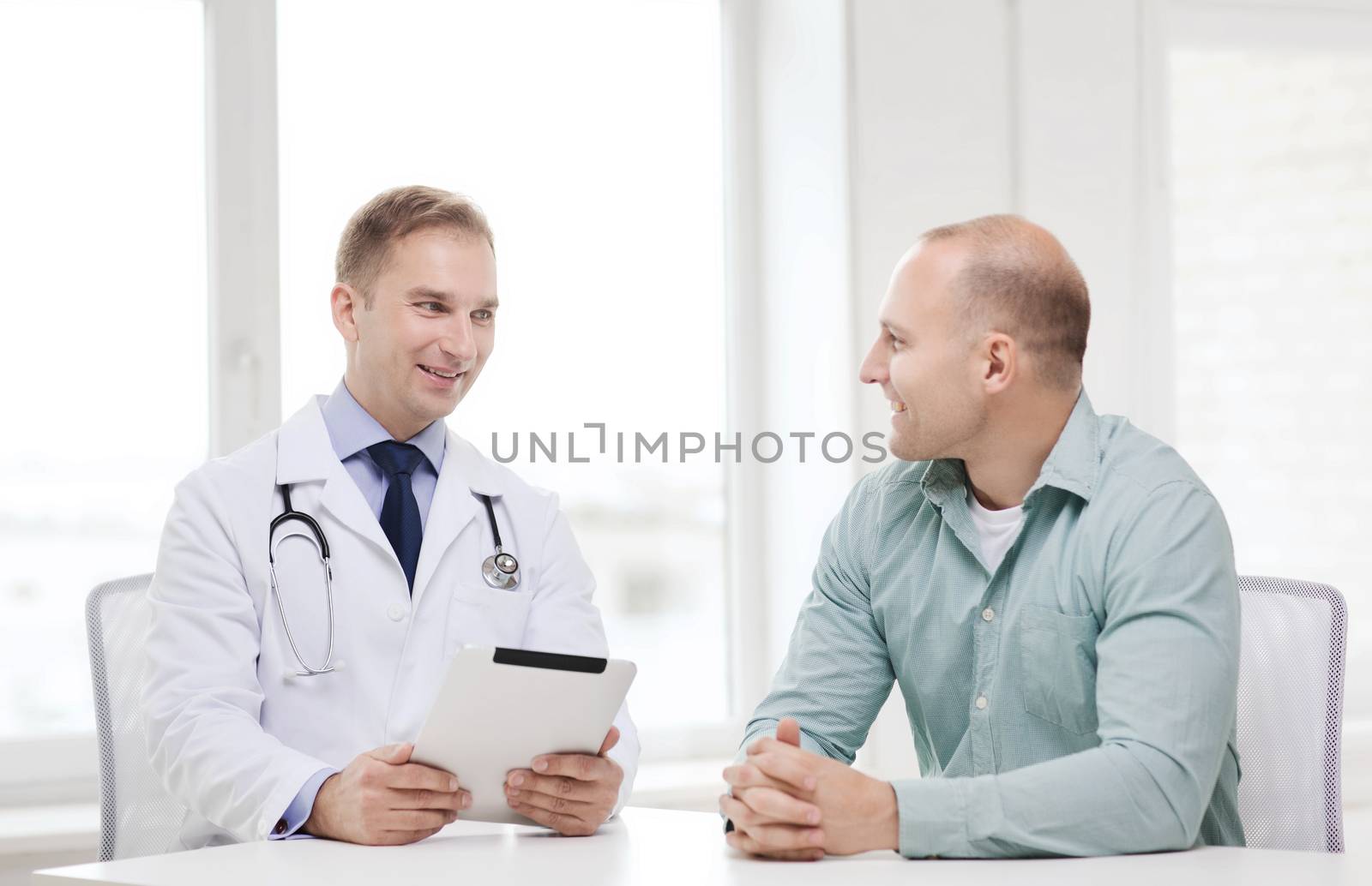 healthcare, technology and medicine concept - smiling doctor with tablet pc computer and patient in hospital