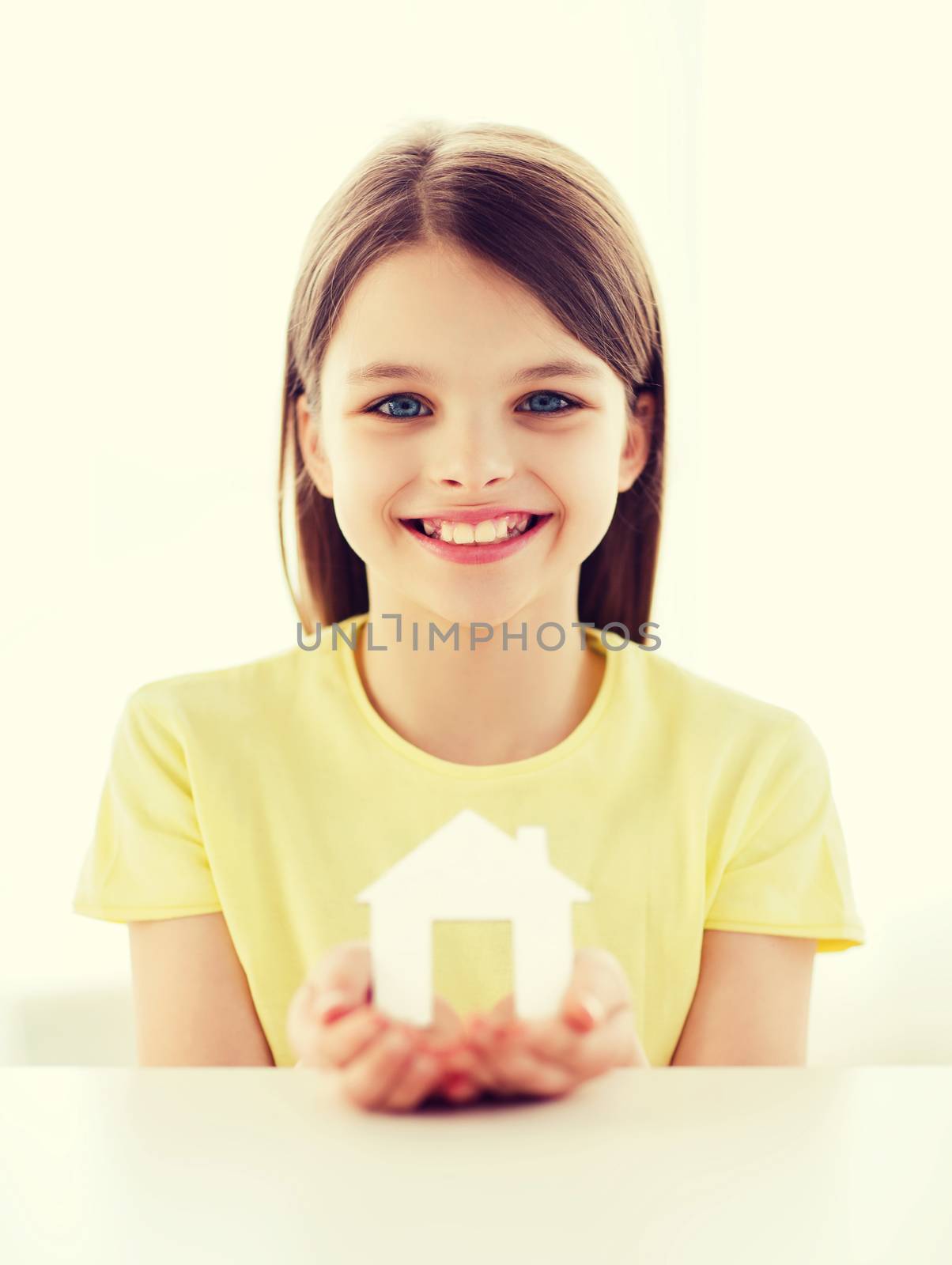 little girl holding white paper house by dolgachov