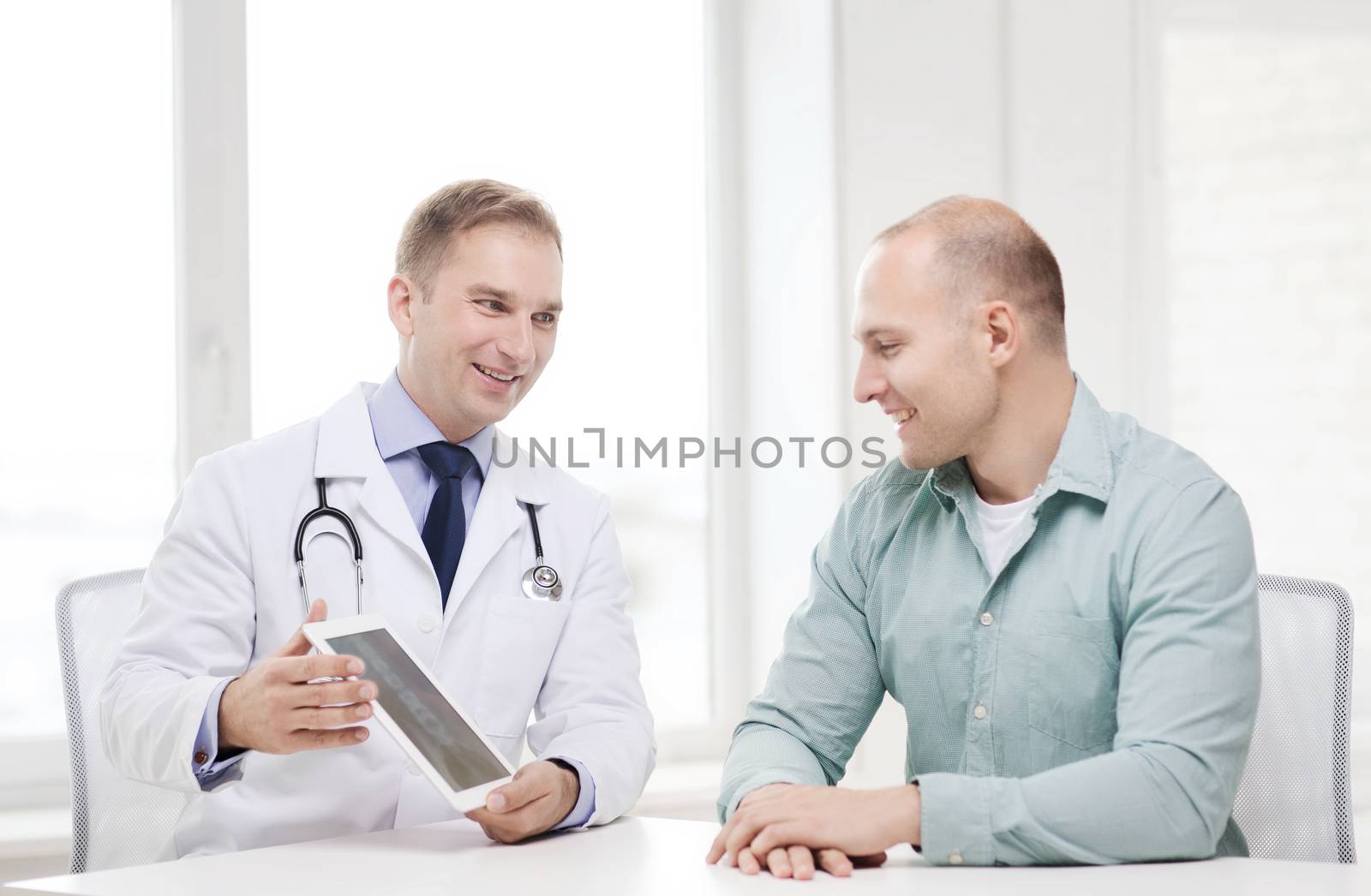 healthcare, technology and medicine concept - smiling doctor with tablet pc computer and patient in hospital