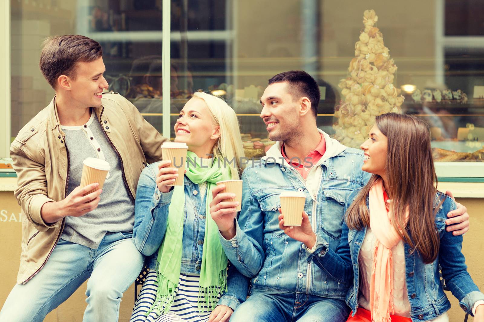 group of smiling friends with take away coffee by dolgachov