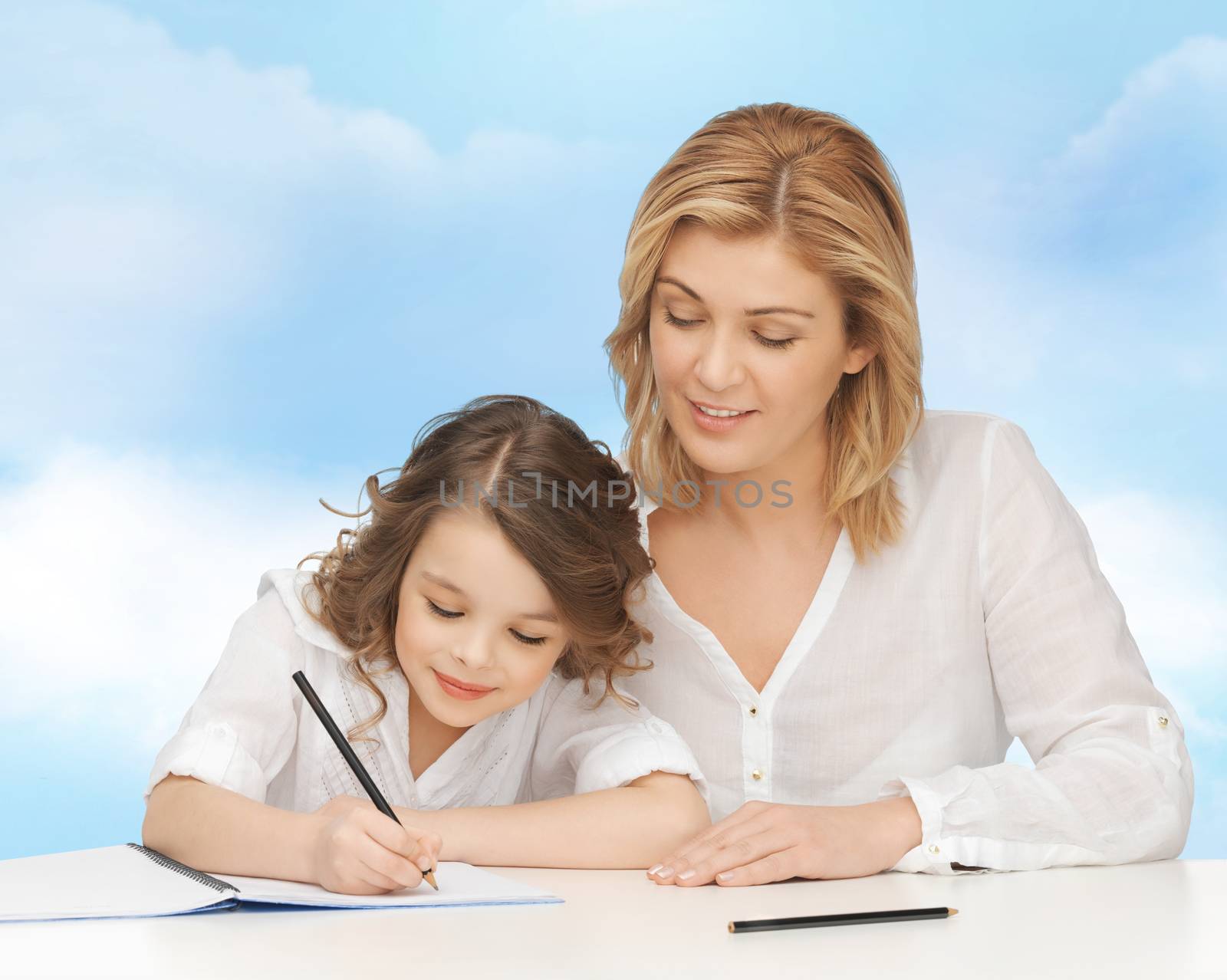 people, family, school, home education and parenting concept -happy mother and daughter doing homework and writing in notebook over blue sky background