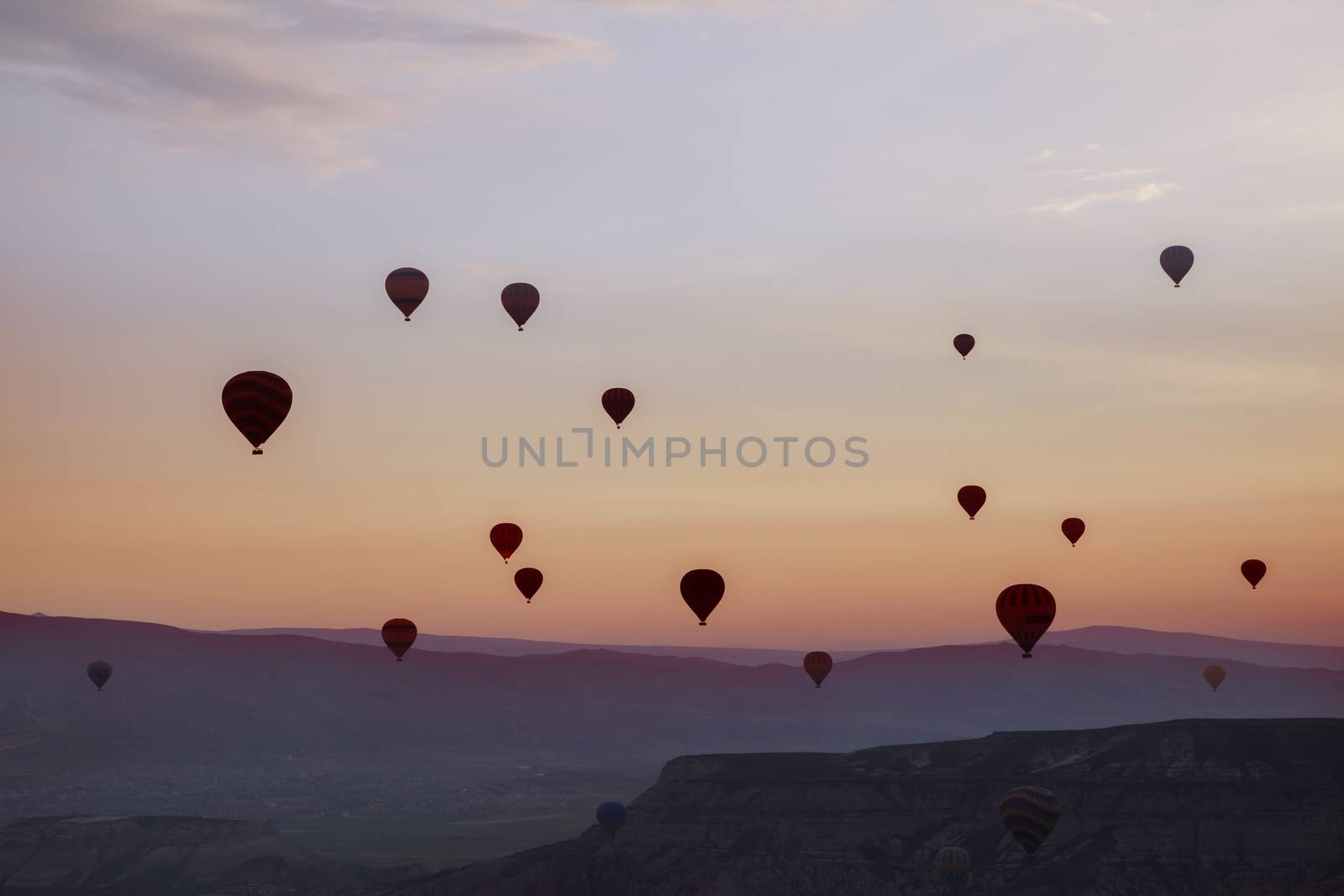 Hot air balloons flying up in the sky in silhouettes 