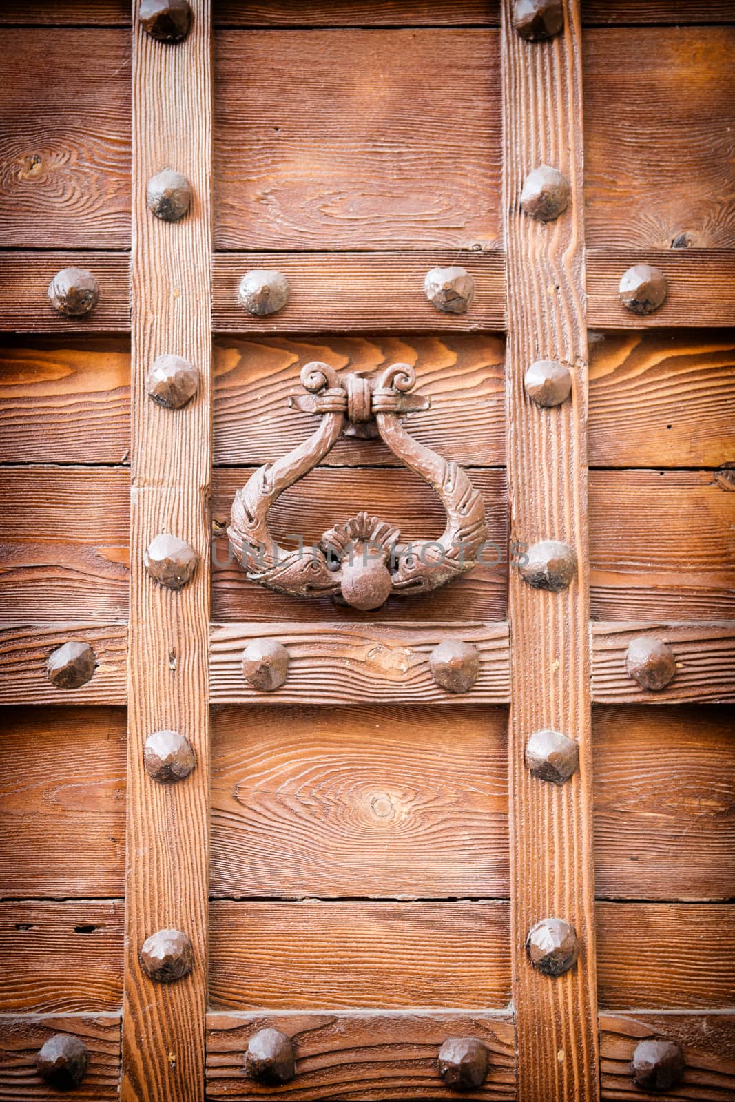 ancient door knocker of a medieval wooden portal