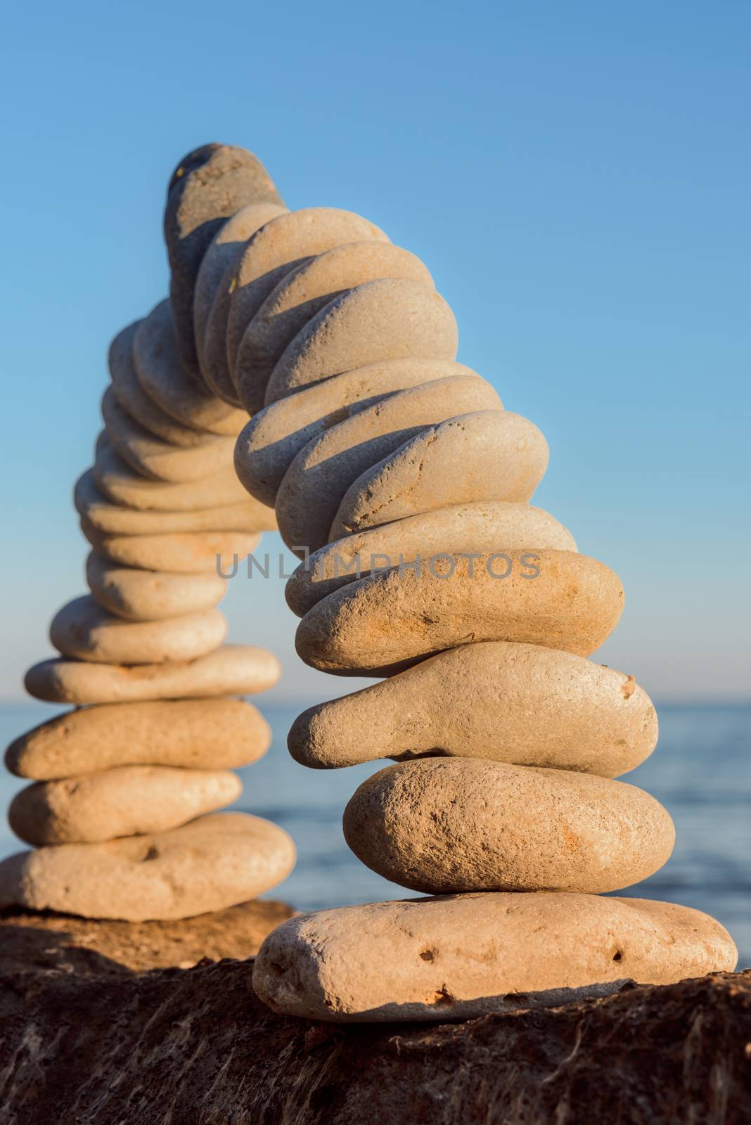 Curve of pebbles in the form of a arch on the coast