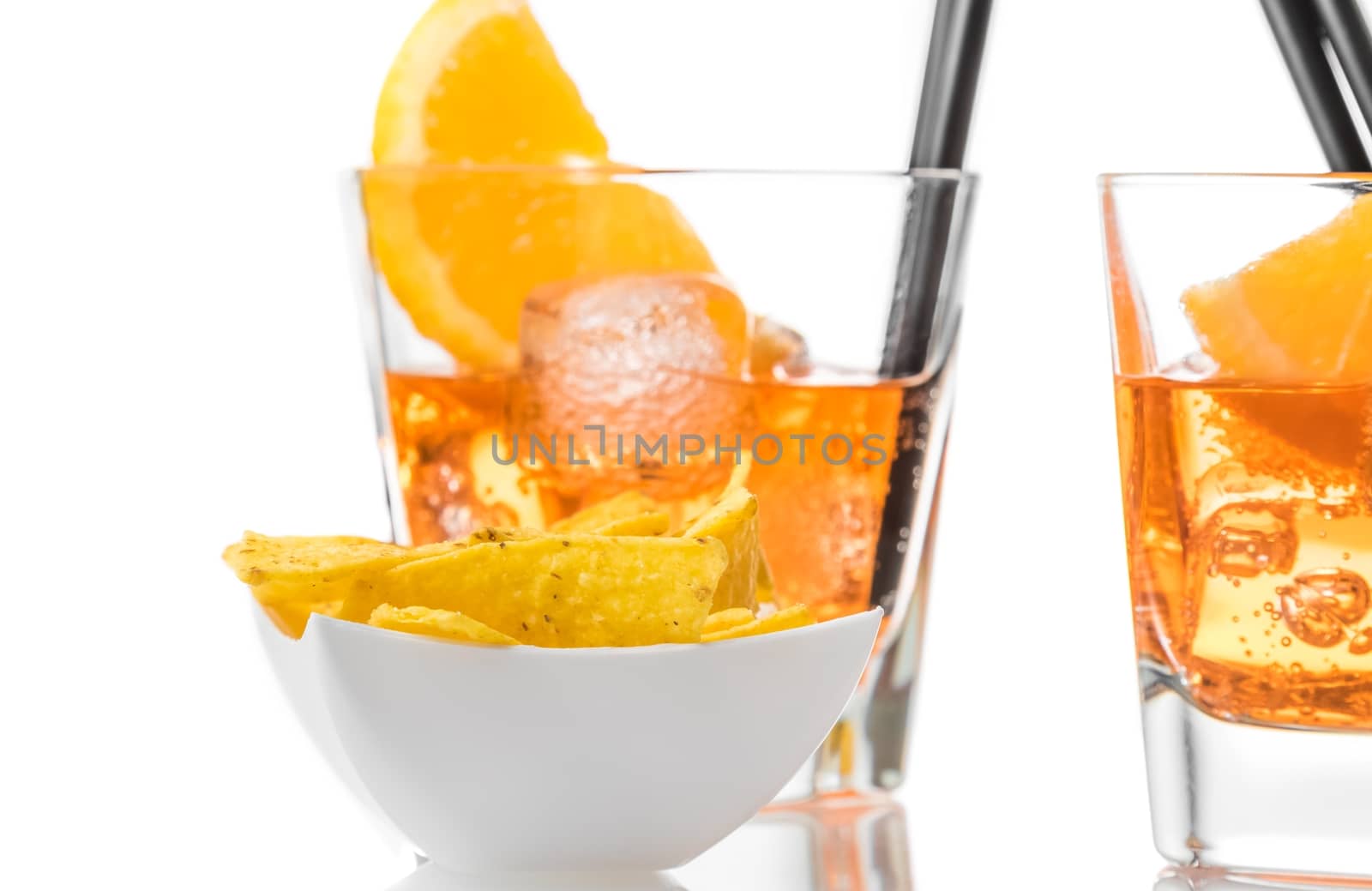 hot tacos chips in front of two glasses of spritz aperitif aperol cocktail with orange slices and ice cubes on white background