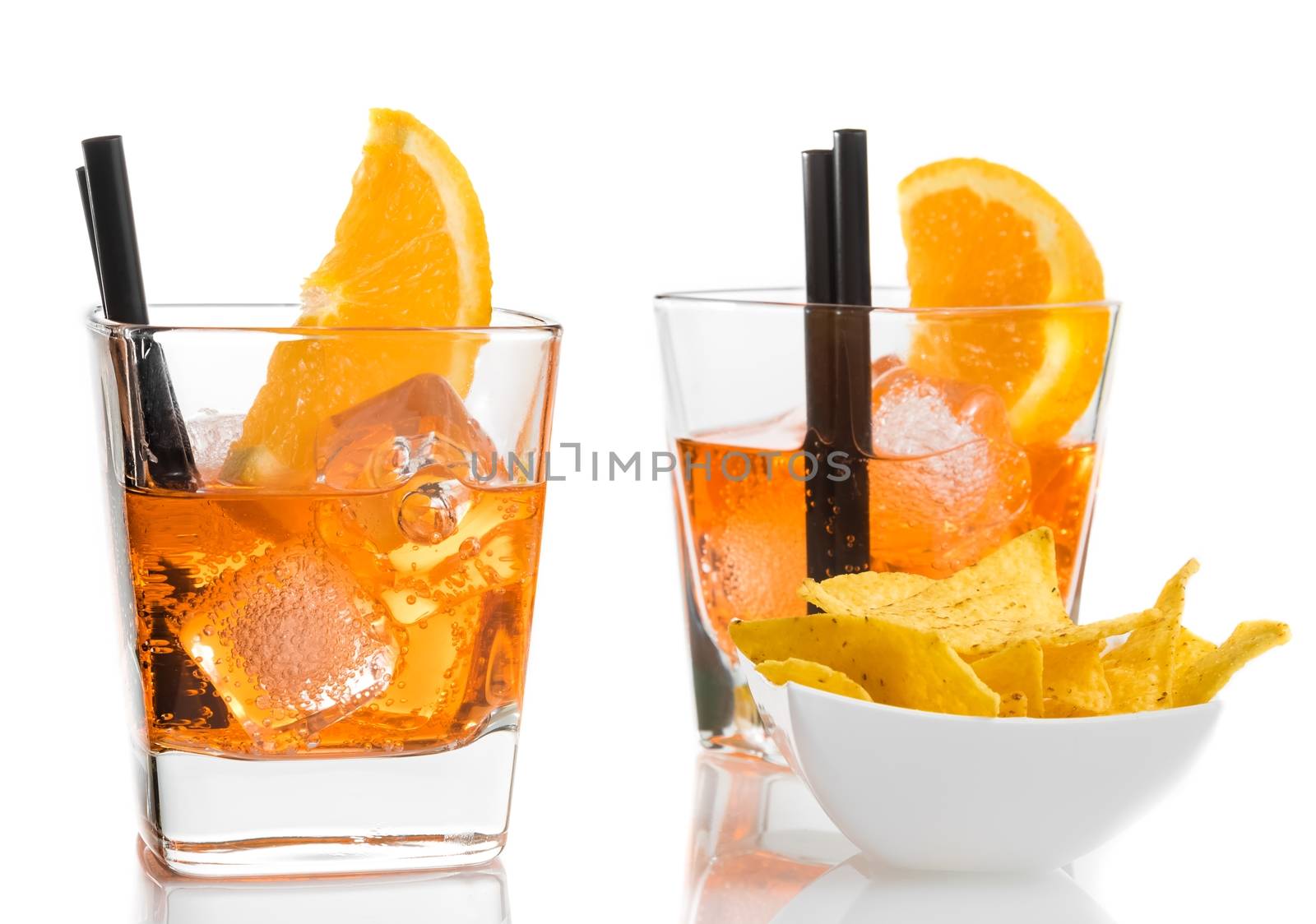 glasses of spritz aperitif aperol cocktail with orange slices and ice cubes near tacos chips on white table background