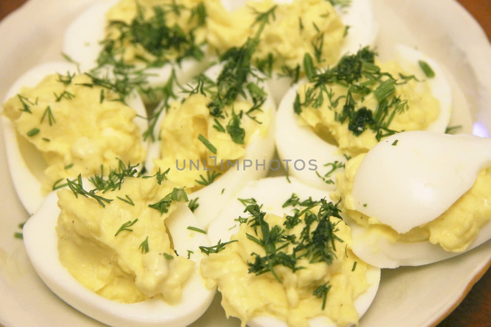 Boiled eggs sliced in halves stuffed and filling by pasta with dill