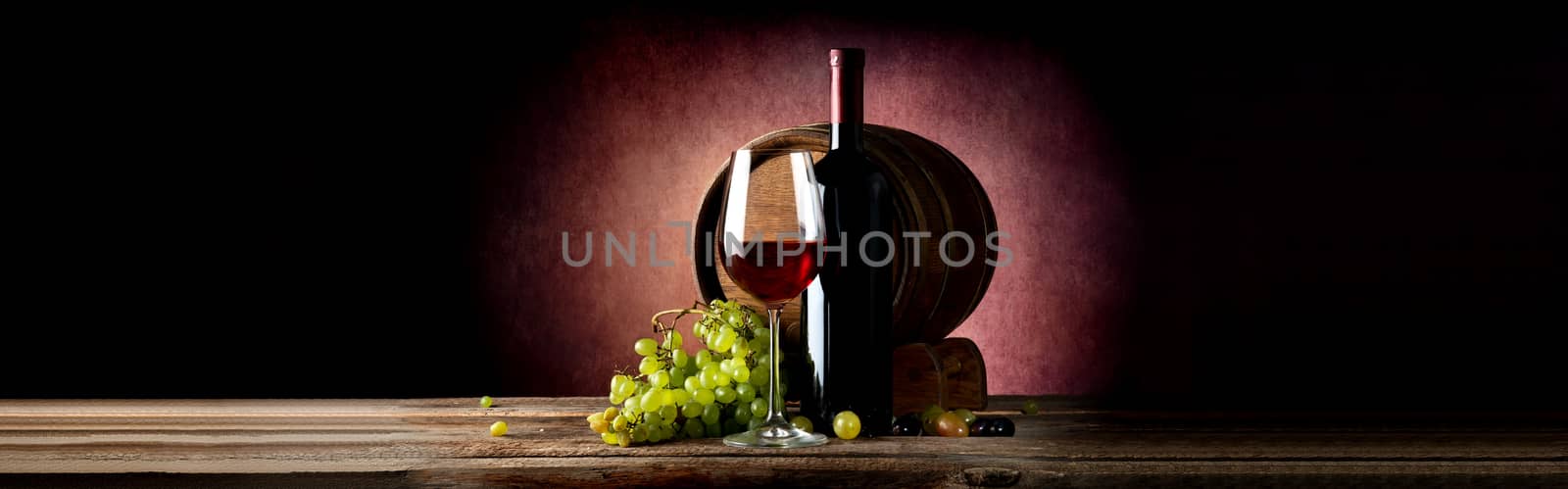 Wine and wooden cask on table and vinous background