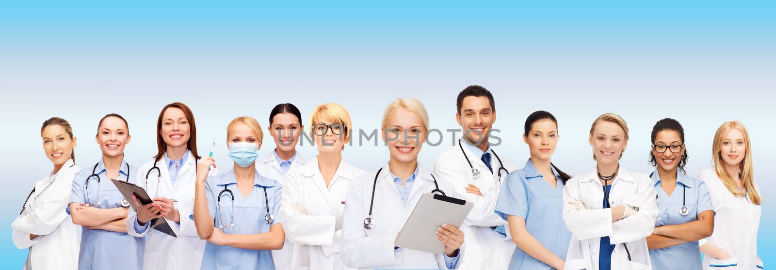 smiling female doctors and nurses with tablet pc by dolgachov