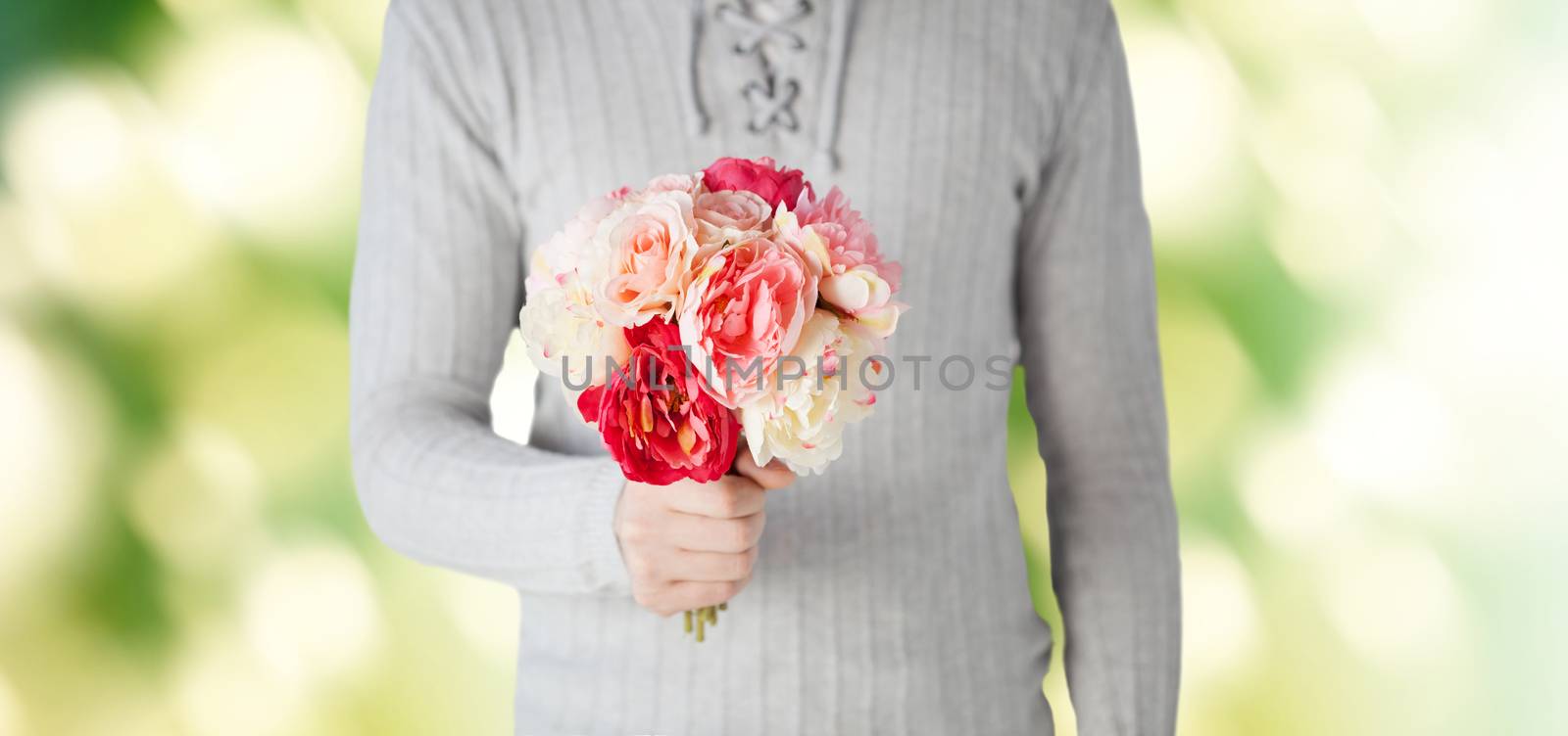 holidays, people, feelings and greetings concept - close up of man holding bunch of flowers over green background