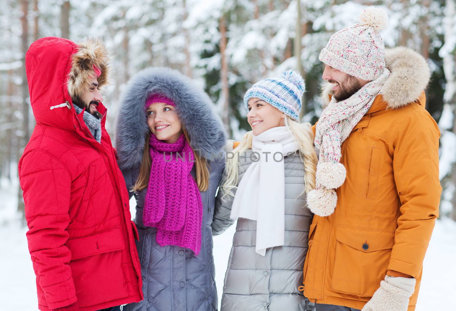group of smiling men and women in winter forest by dolgachov