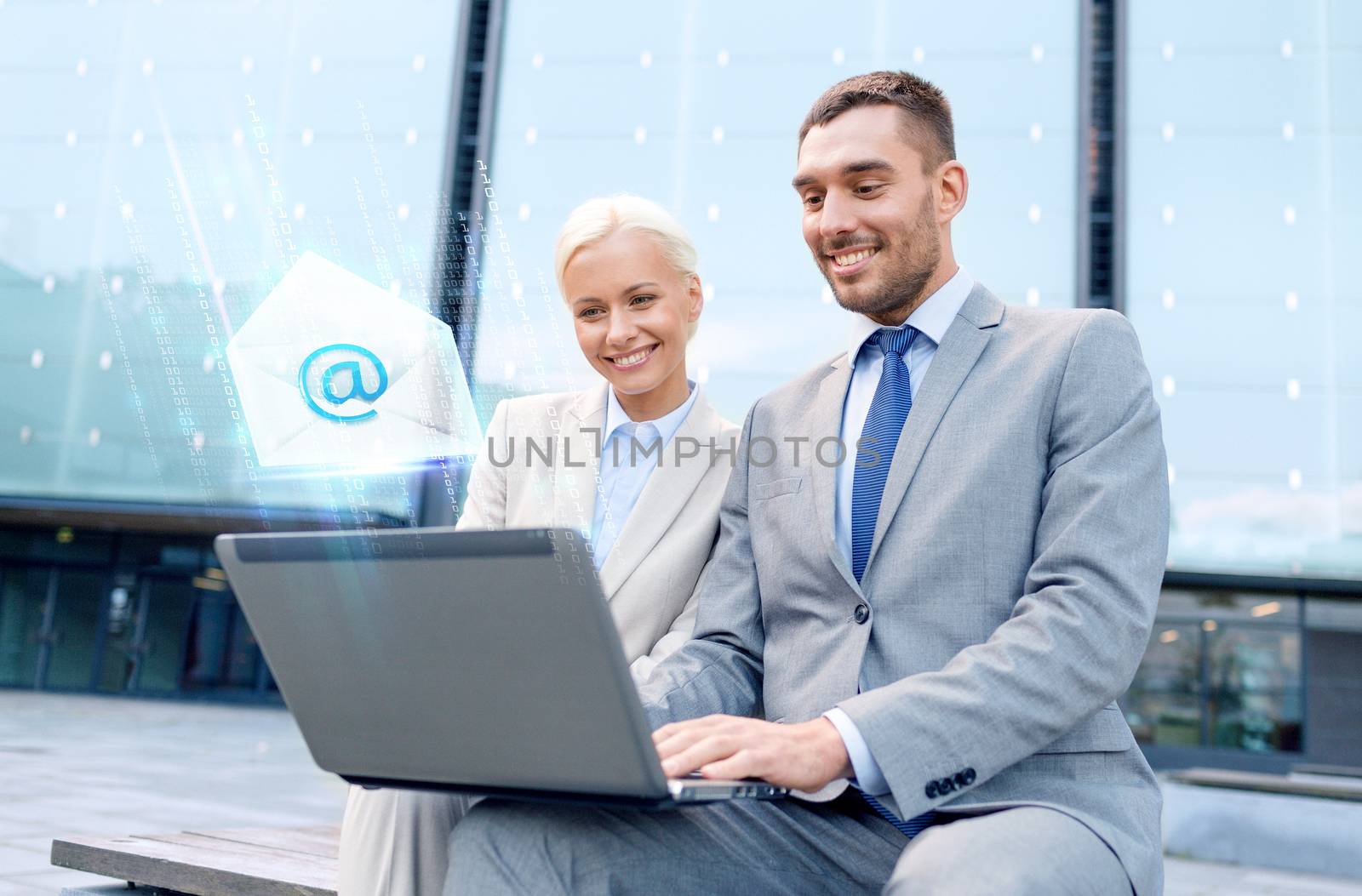 smiling businesspeople with laptop sending e-mail by dolgachov