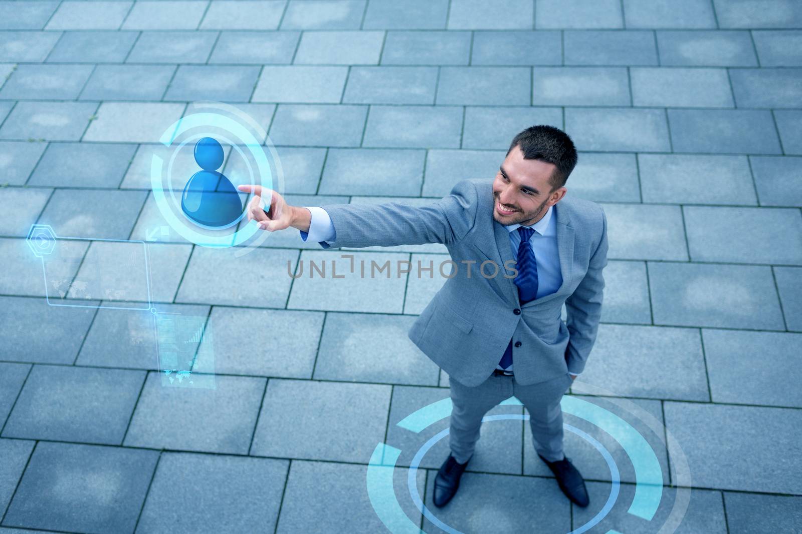 business, development, technology, connection and people concept - young smiling businessman pointing finger to user icon on virtual screen outdoors from top