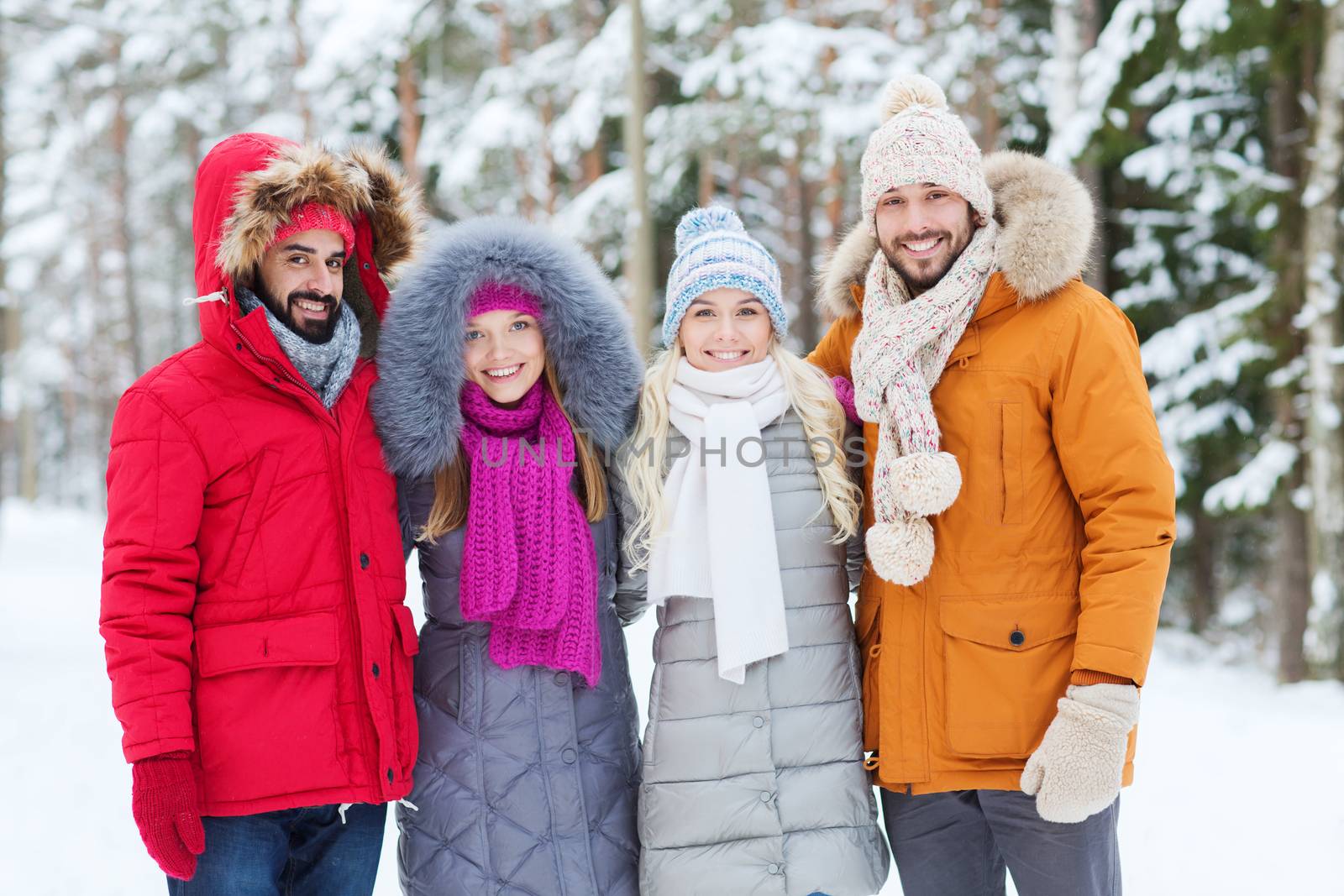 love, relationship, season, friendship and people concept - group of smiling men and women walking in winter forest