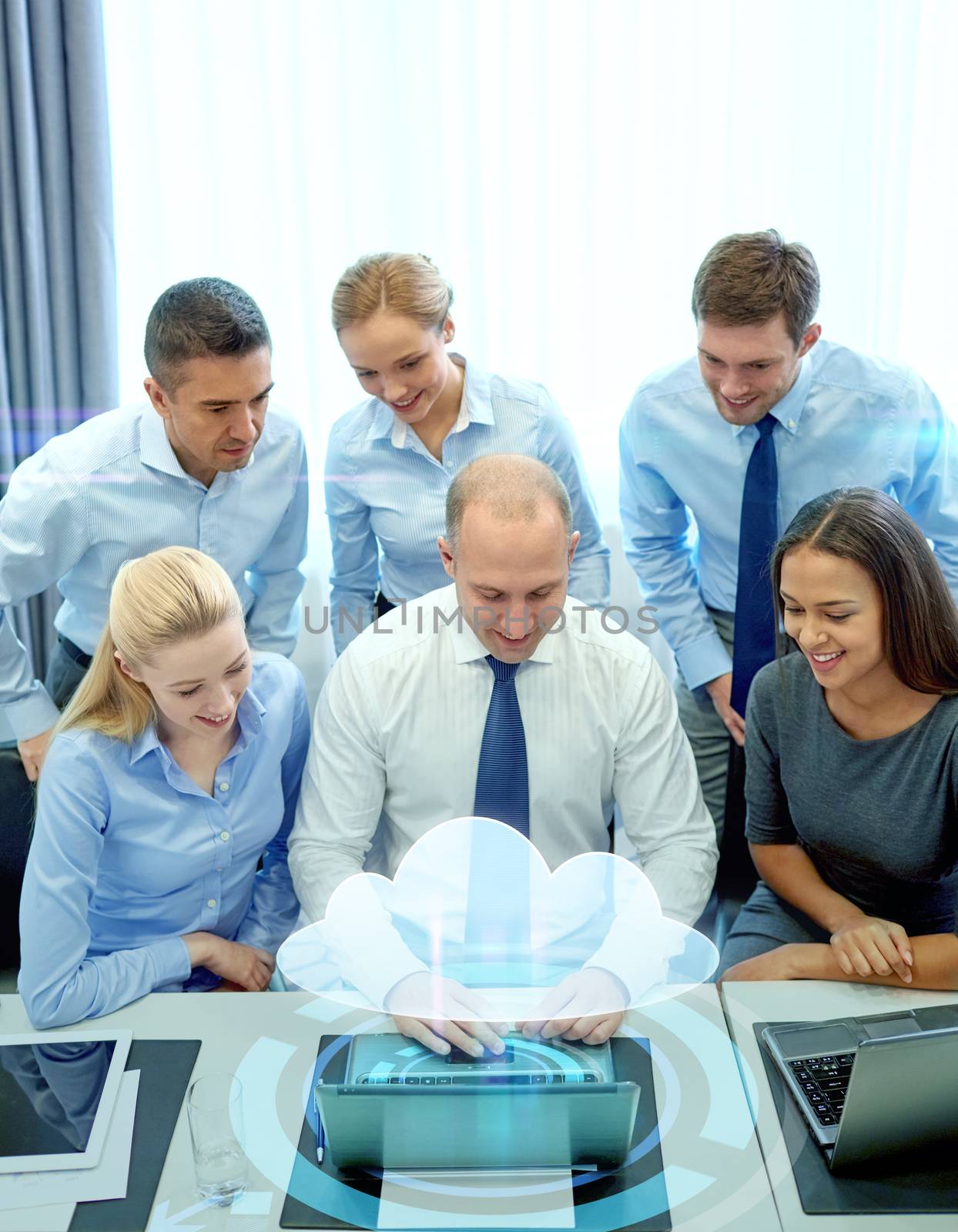 smiling business people with laptop in office by dolgachov