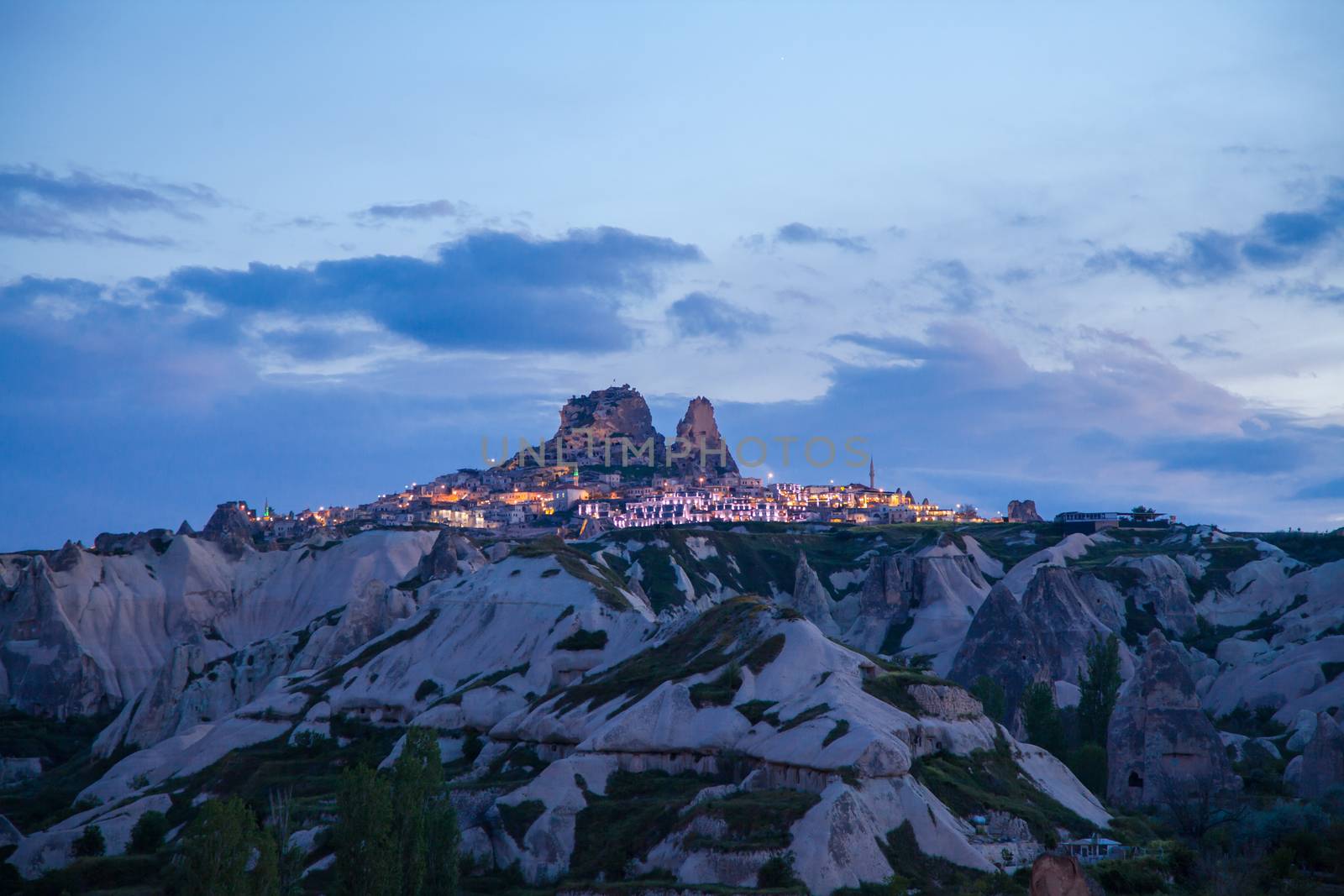 Uchisar lit up as sun sets, in Goreme, Cappadocia, Turkey