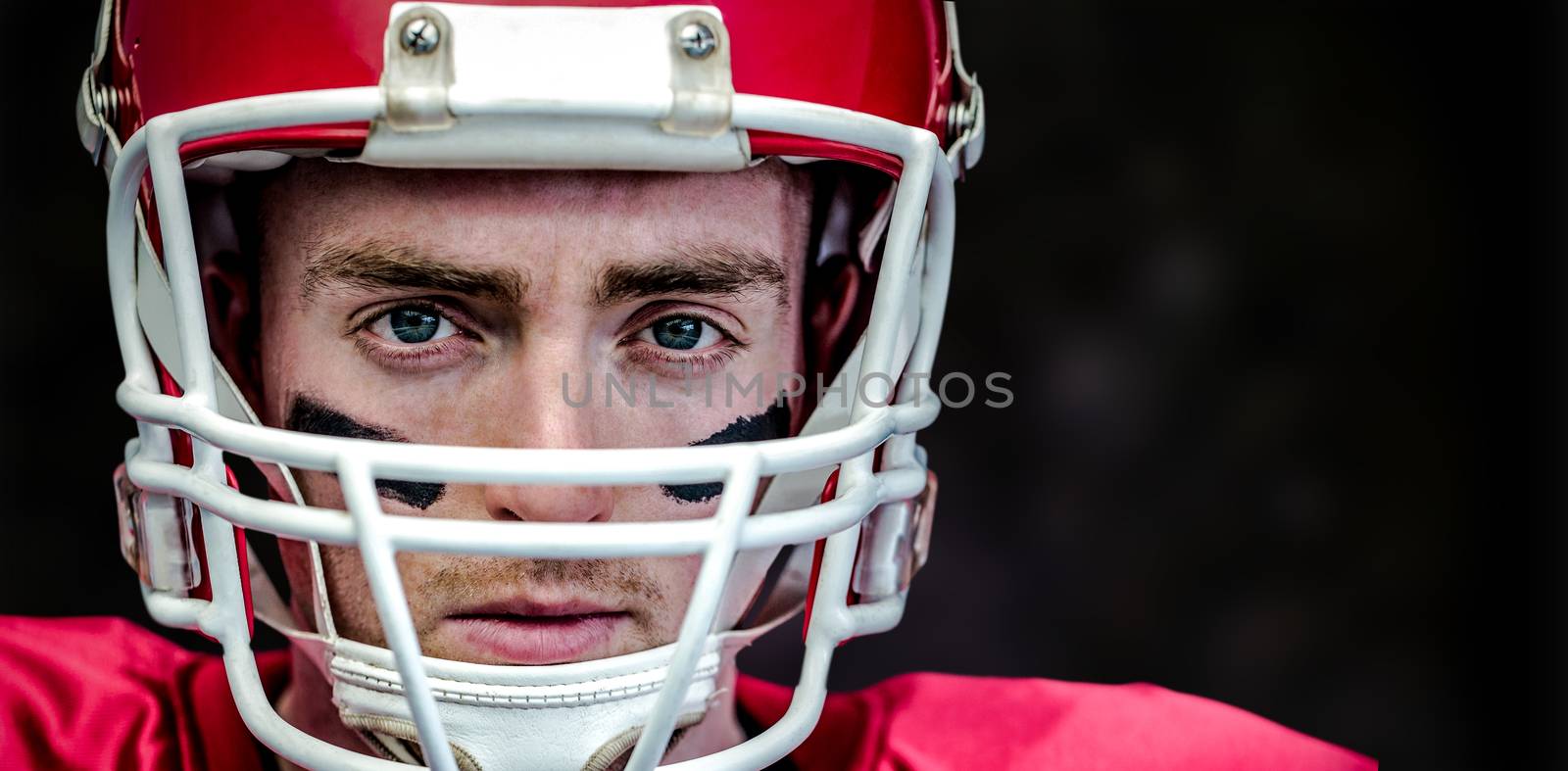 Composite image of portrait of focused american football player wearing his helmet by Wavebreakmedia