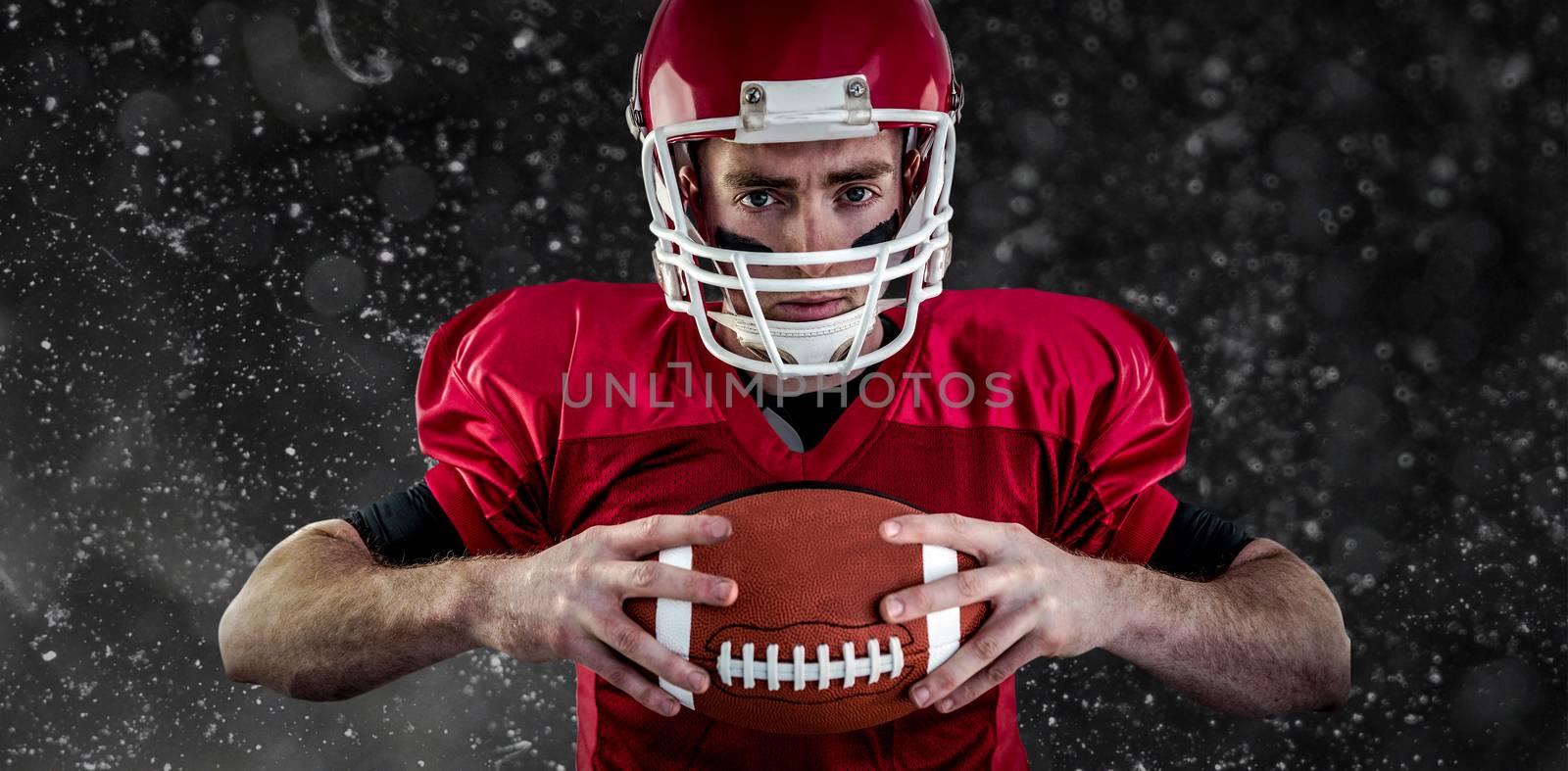 Portrait of focused american football player against black background