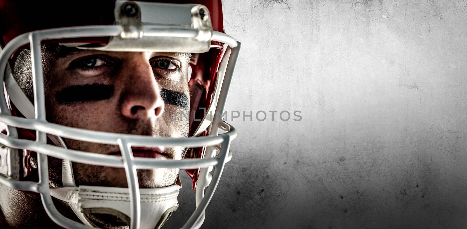 American football player looking at camera against grey background
