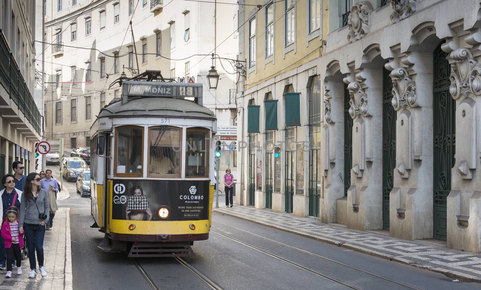 LISBON, PORTUGAL - SEPTEMBER 26: Unidentified people sitting in the Yellow tram  goes by the street of Lisbon city center on September 26, 2015. Lisbon is a capital and must famous city of Portugal