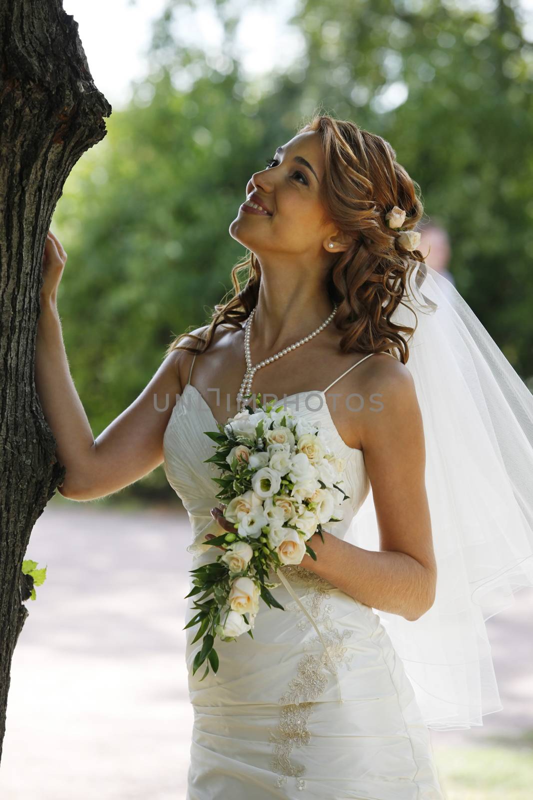 The beautiful bride with bouquet in park