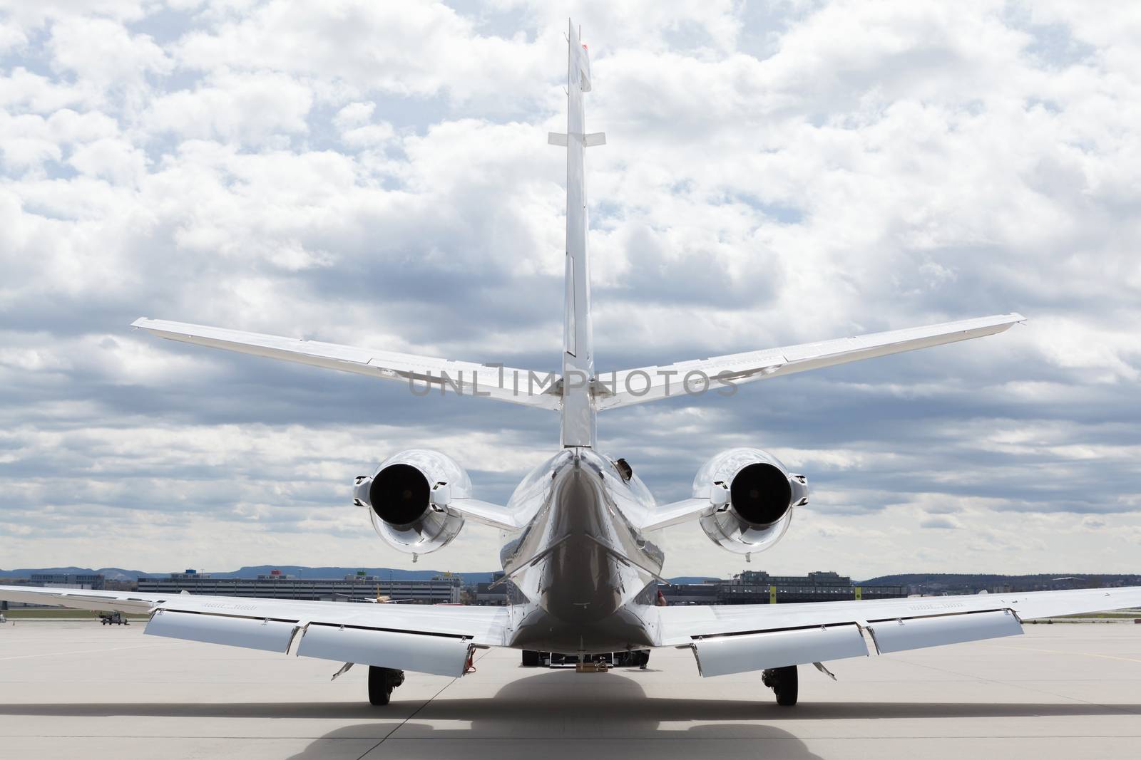 Aircraft learjet Plane in front of the Airport with cloudy sky and sun