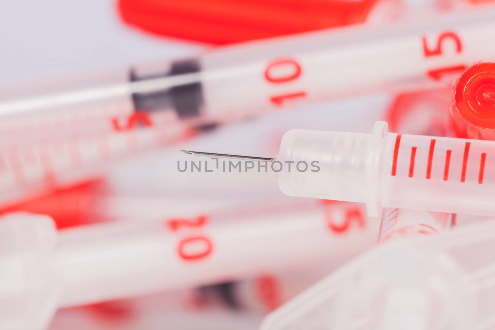 Pile of Empty Syringes with Red Safety Caps by juniart
