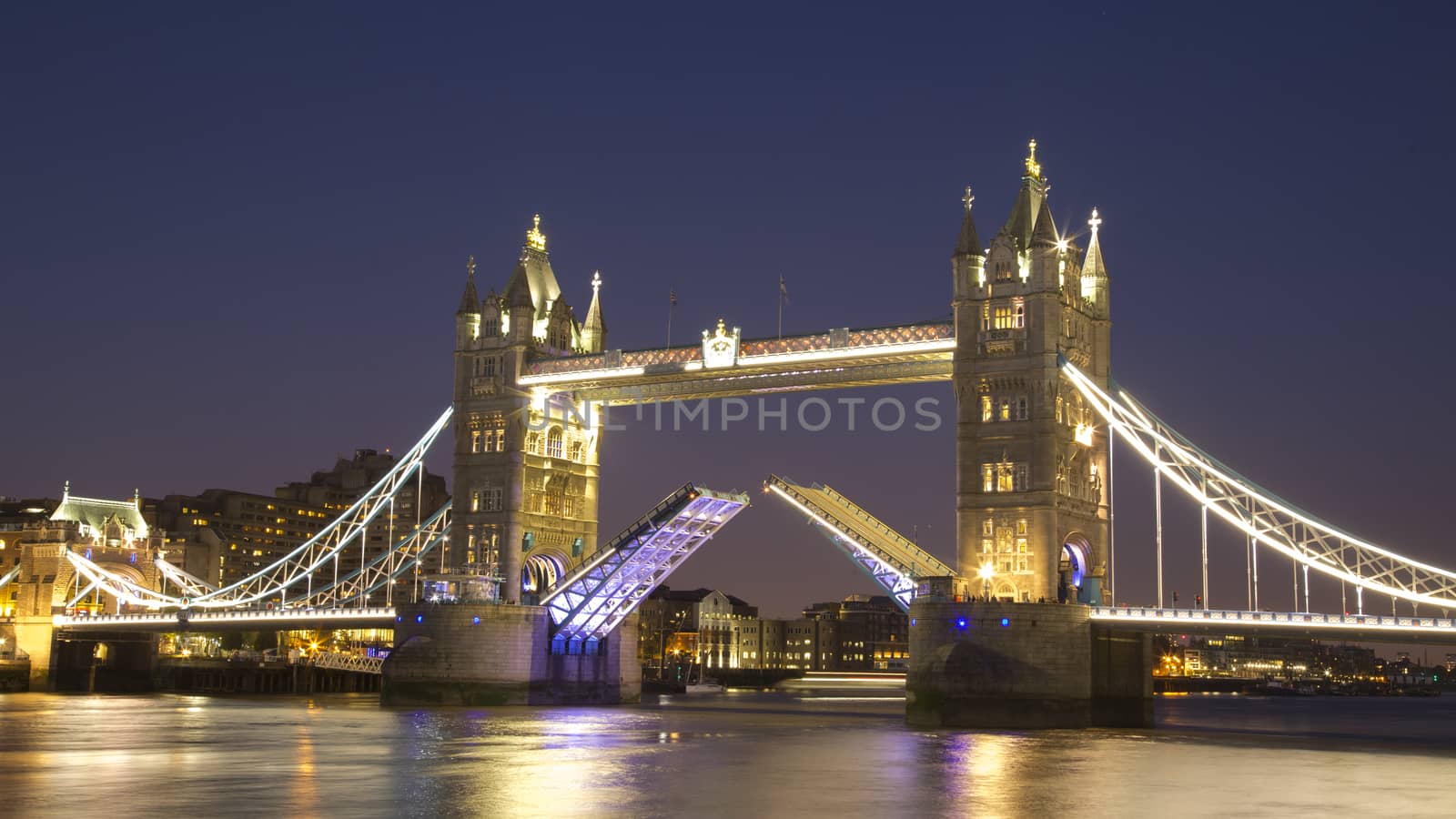 Tower bridge raised at night, London, UK