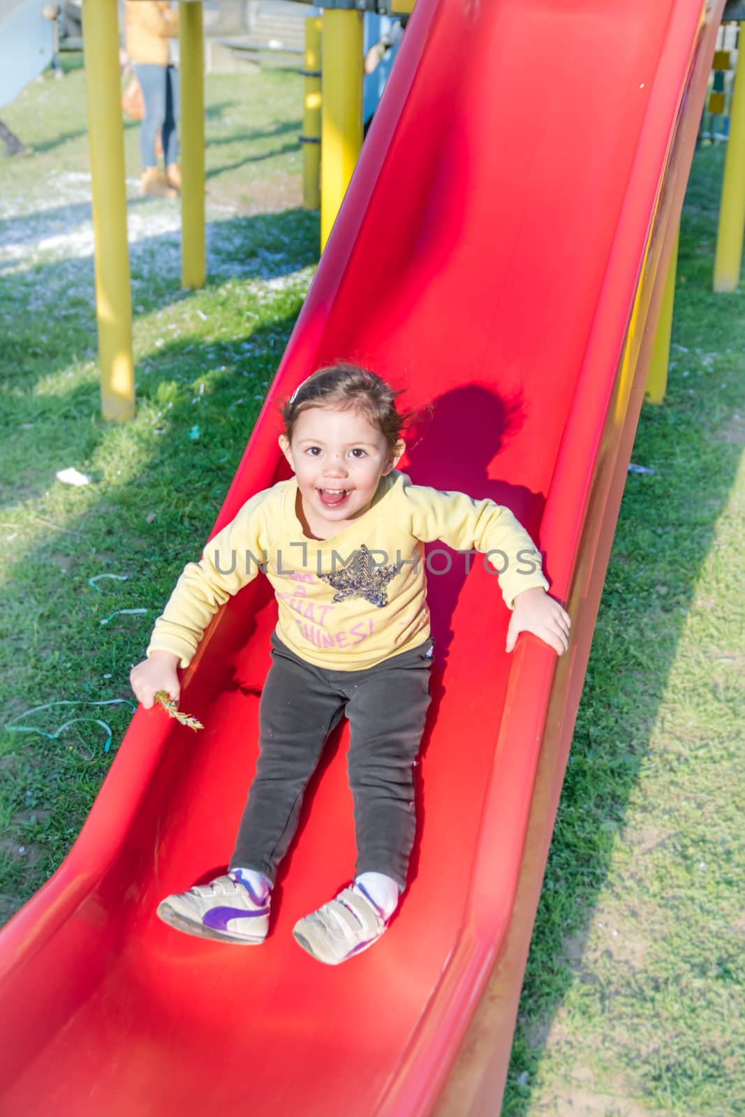 child falls from the red slide in a playground