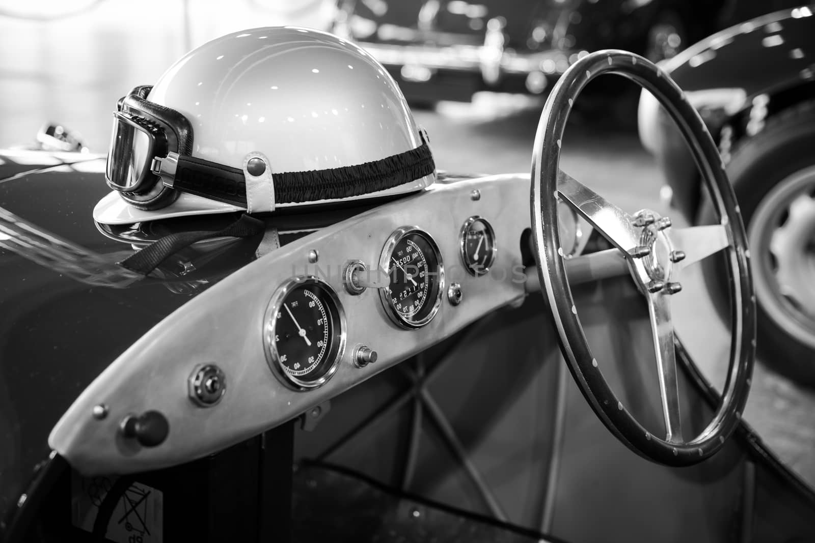 helmet and glasses resting on a old vintage sports car