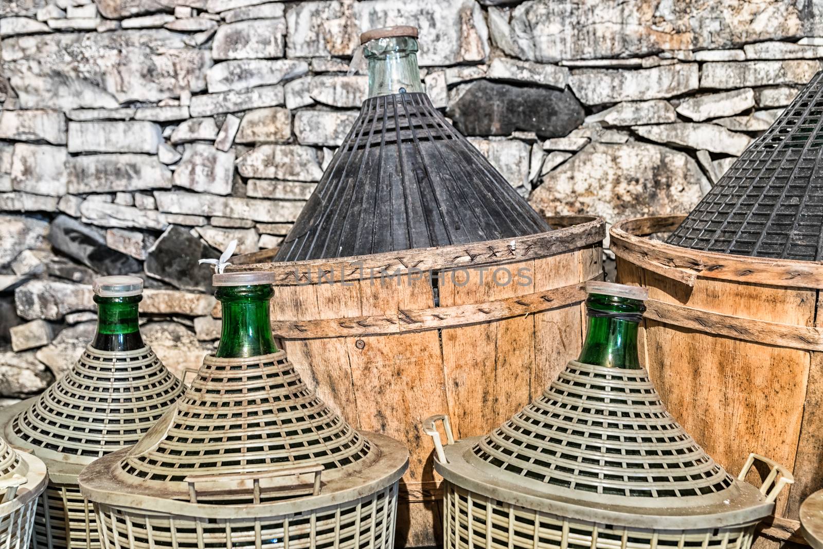 Demijohns of wine in a stone cellar.