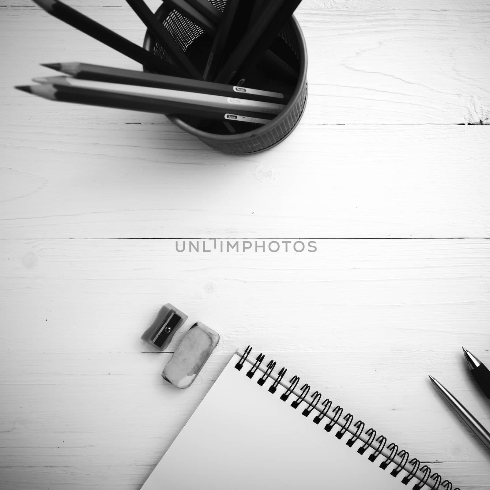 notepad with color pencil on white table view from above black and white color style