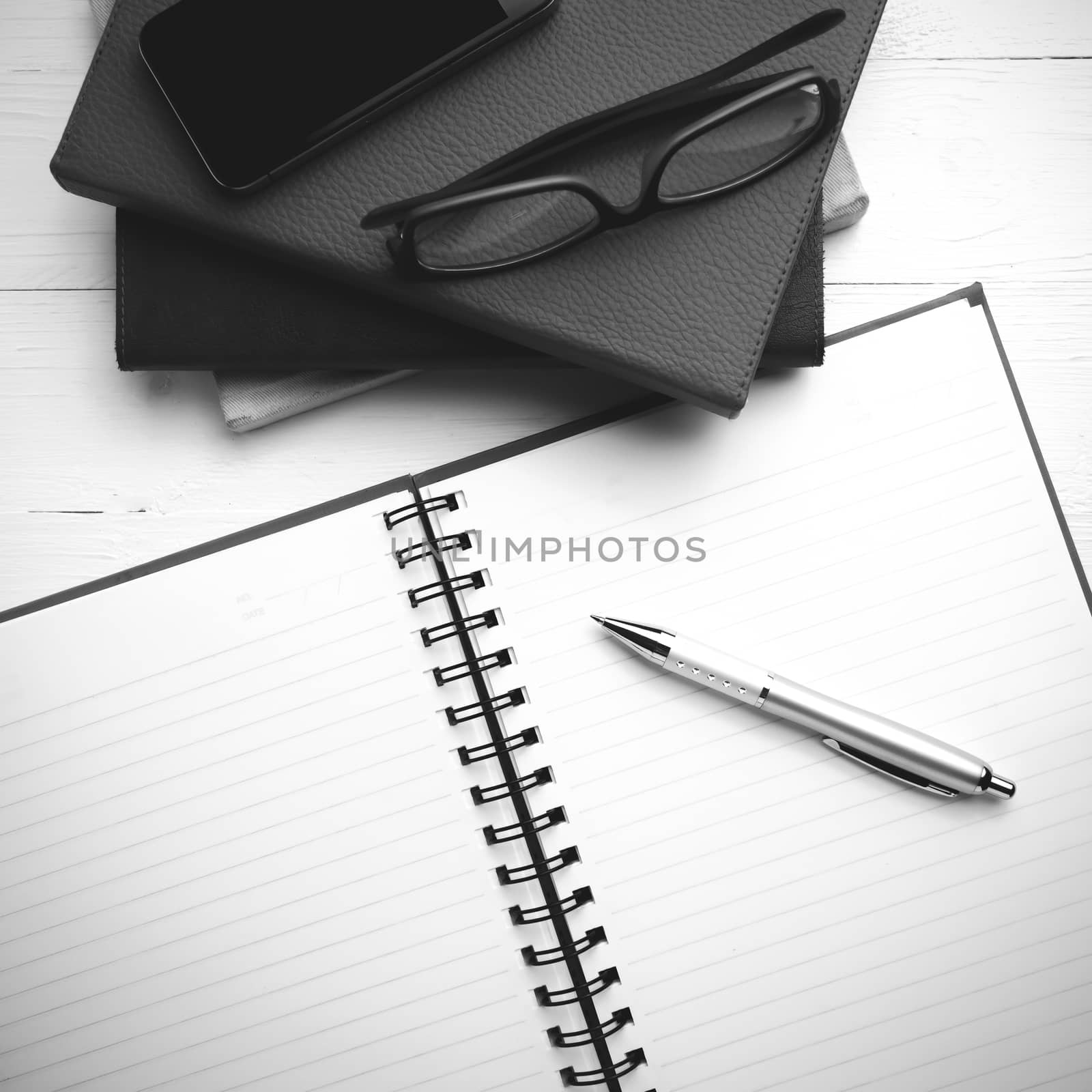 notepad with stack of book on table view from above black and white tone color style