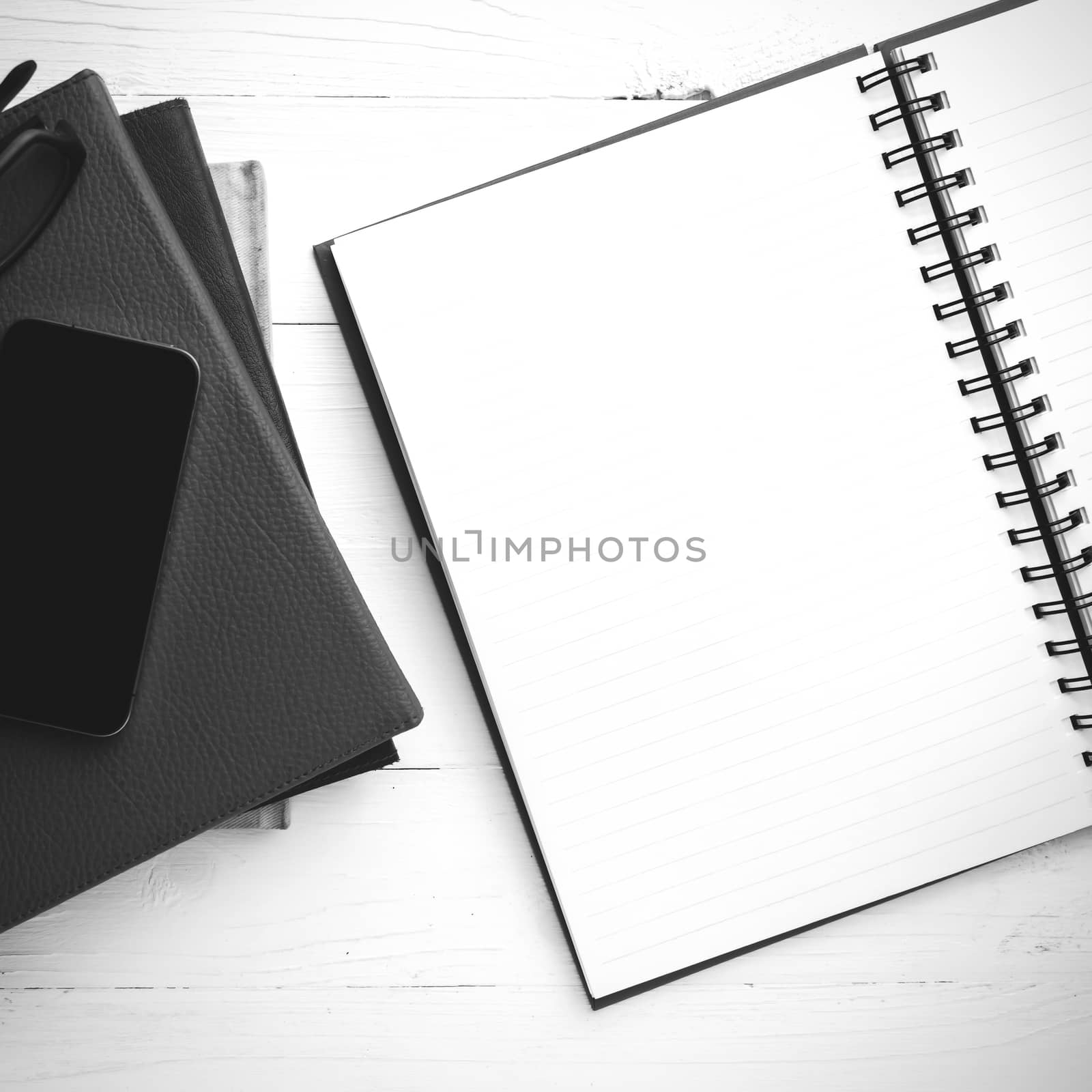 notepad with stack of book on table view from above black and white tone color style