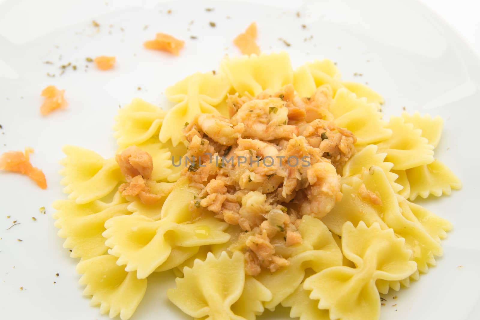 italian traditional pasta called butterflies with shrimp salmon and basil