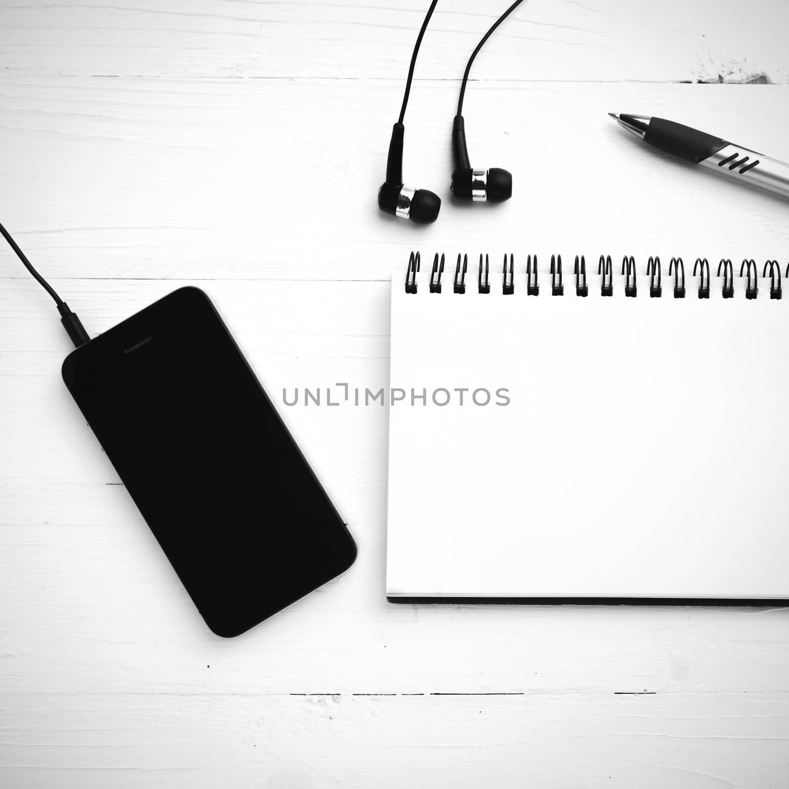 notepad and cellphone over white table black and white color tone style