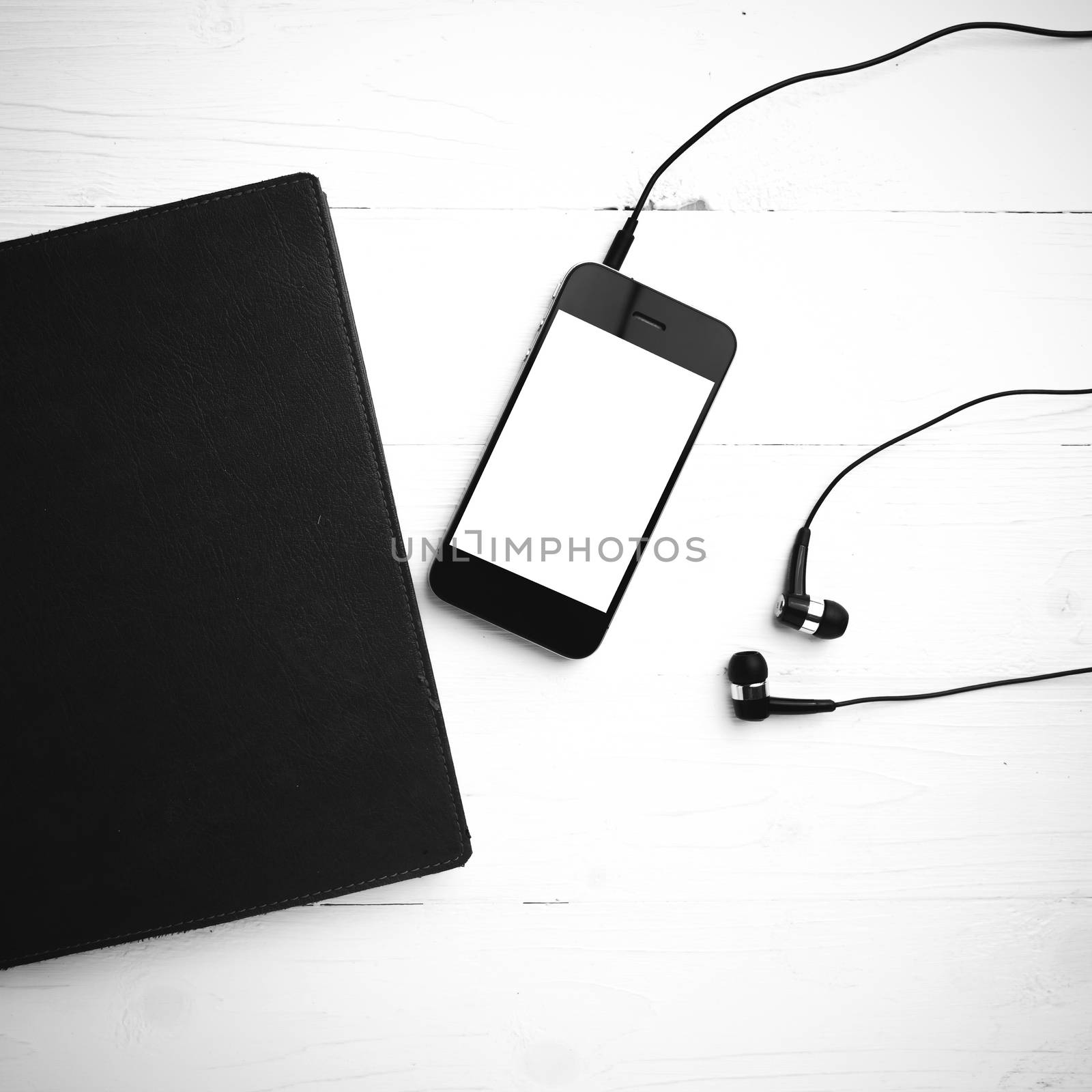 cellphone and notebook over white table black and white color tone style