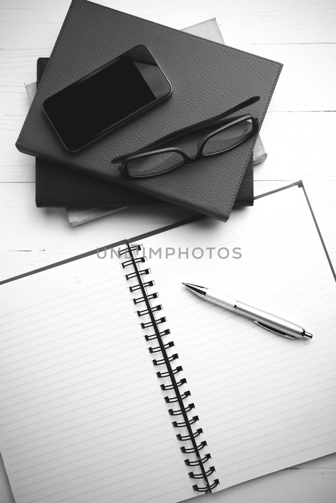 notepad with stack of book on table view from above black and white tone color style