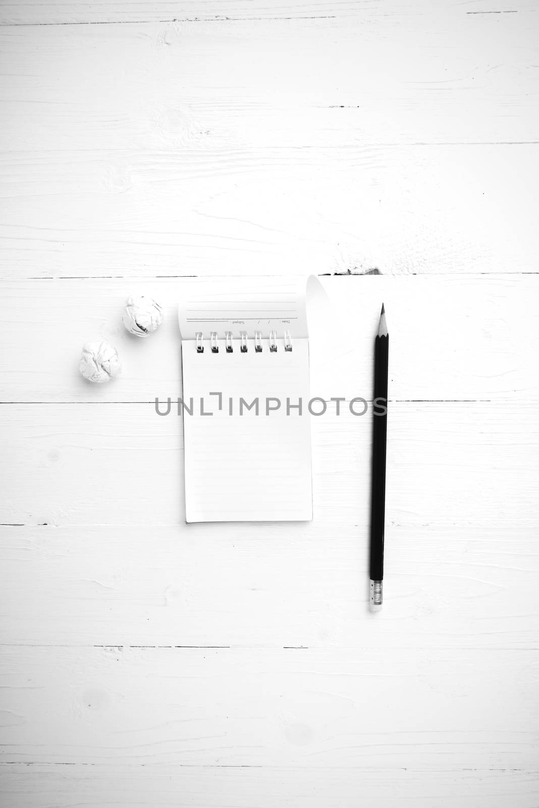 notepad with crumpled paper and pencil over white table black and white tone color style