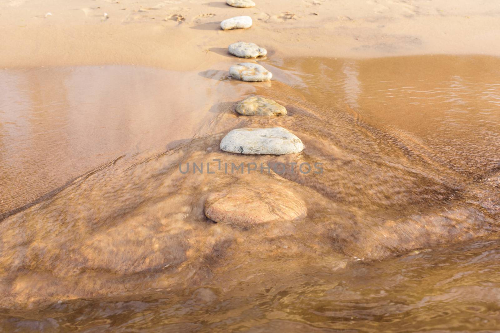Stone footpath on the sandy beach